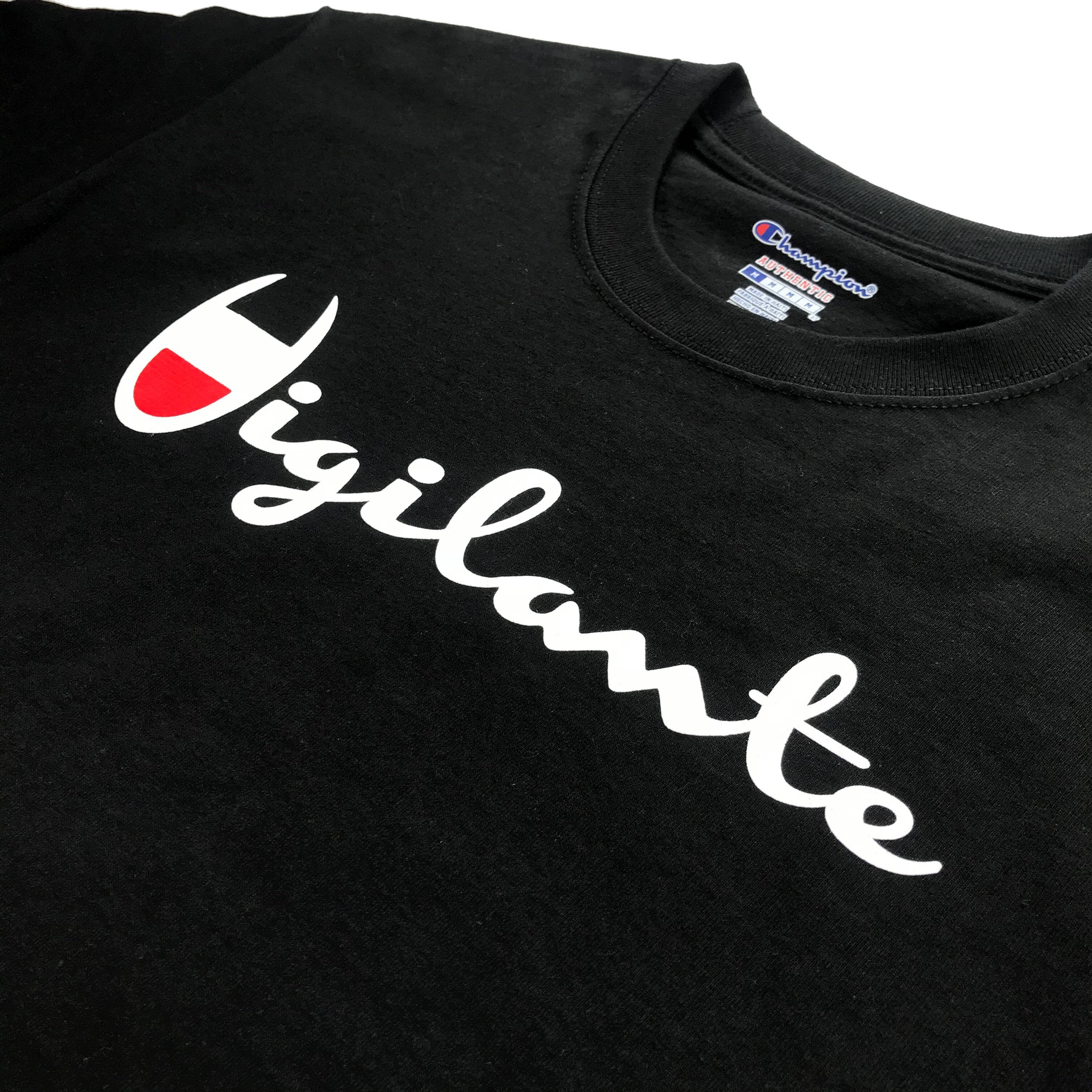 Champion 桌布 壁紙 — 黑色Champion T恤特寫，胸前有白色草書 'Higilante' 文字和紅白標誌。