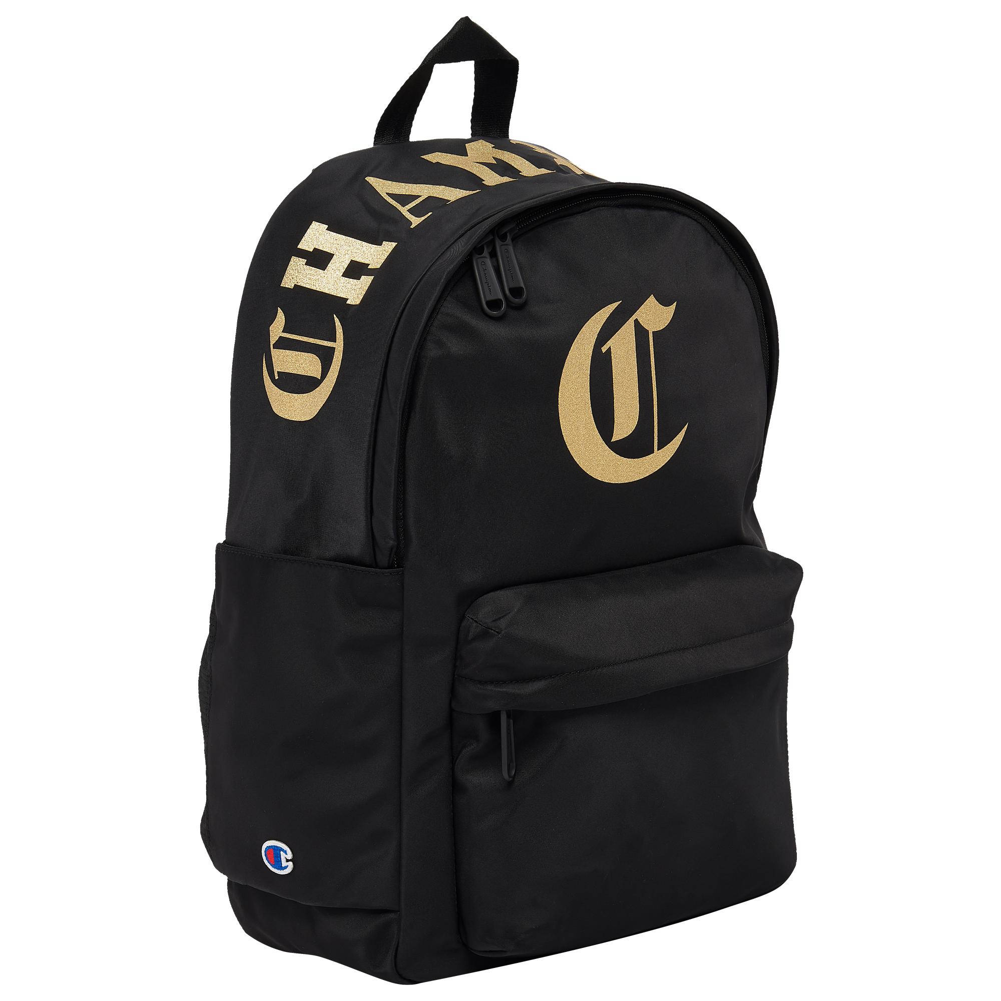 Champion 桌布 壁紙 — 黑色Champion背包，帶有金色'CHAMP'字樣和標誌，背景為純白色。