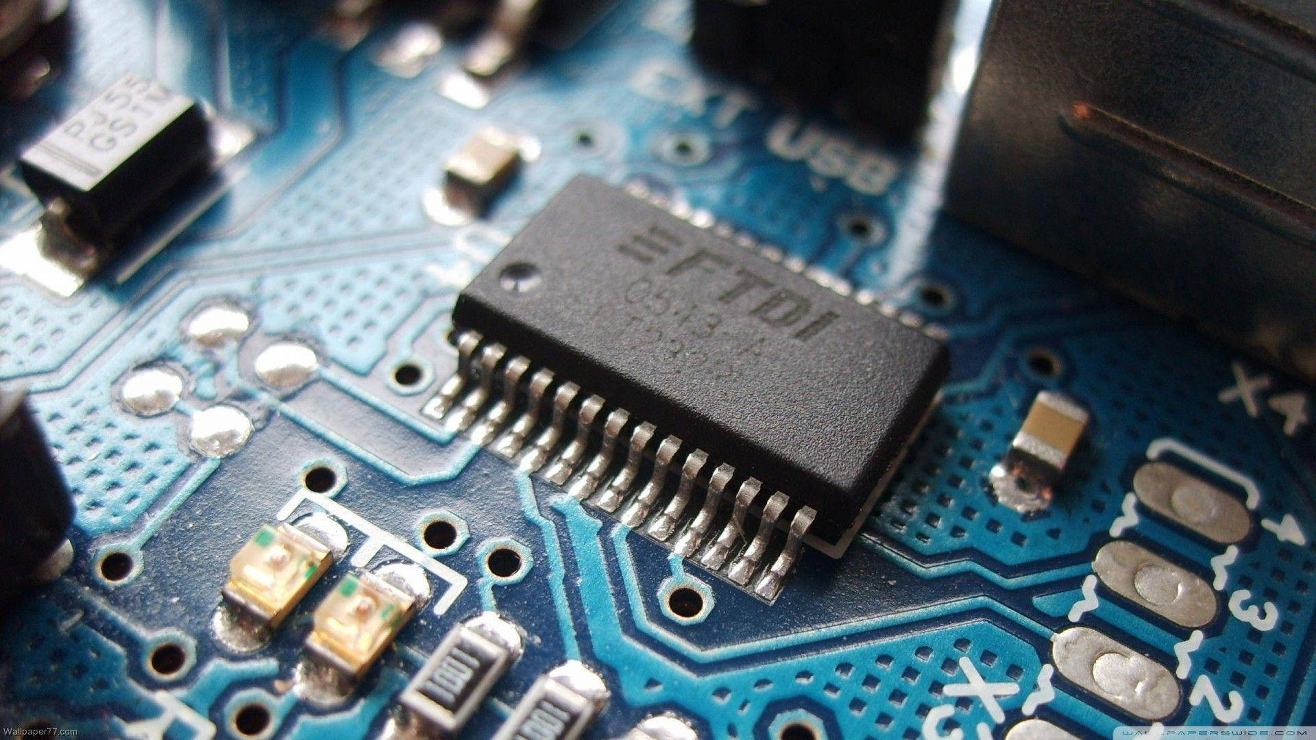 Motherboard 桌布 壁紙 — 黑色EFTDI晶片在藍色電路板上的特寫，帶有銀色焊點和細小電子元件。