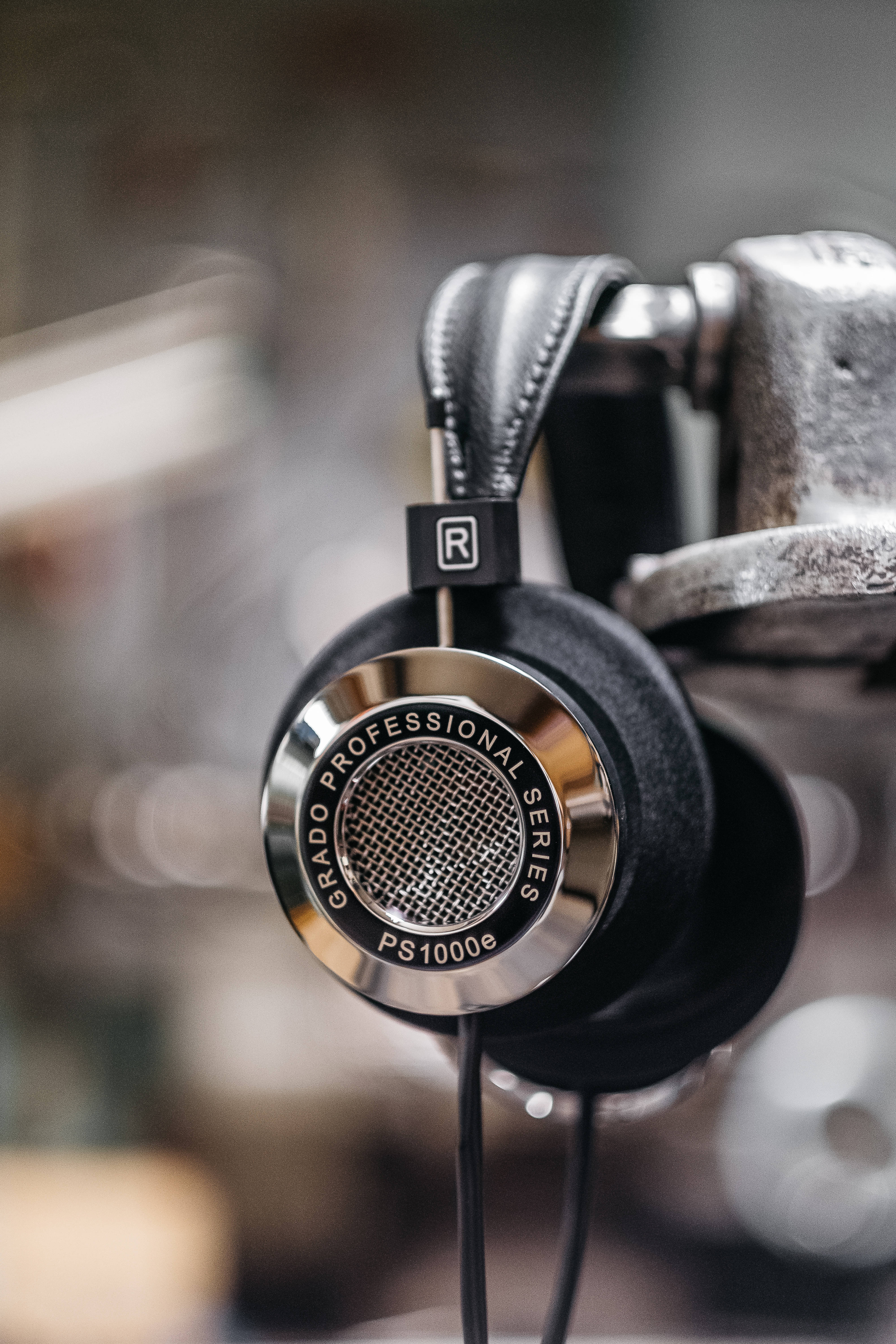 音樂 桌布 壁紙 — 黑色Grado PS1000e耳機特寫，設計時尚，帶金屬裝飾，置於紋理支架上。