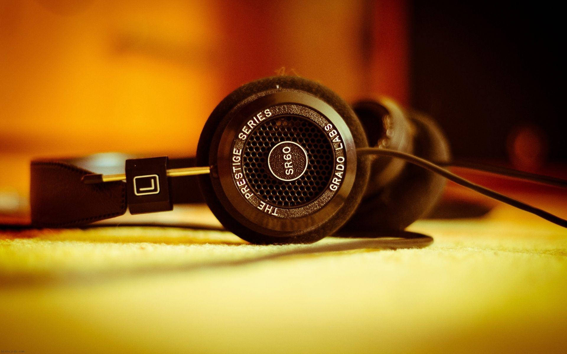 酷炫高畫質 桌布 壁紙 — 黑色Grado SR60耳機特寫，放在柔軟的黃色表面上，溫暖的金色燈光下。