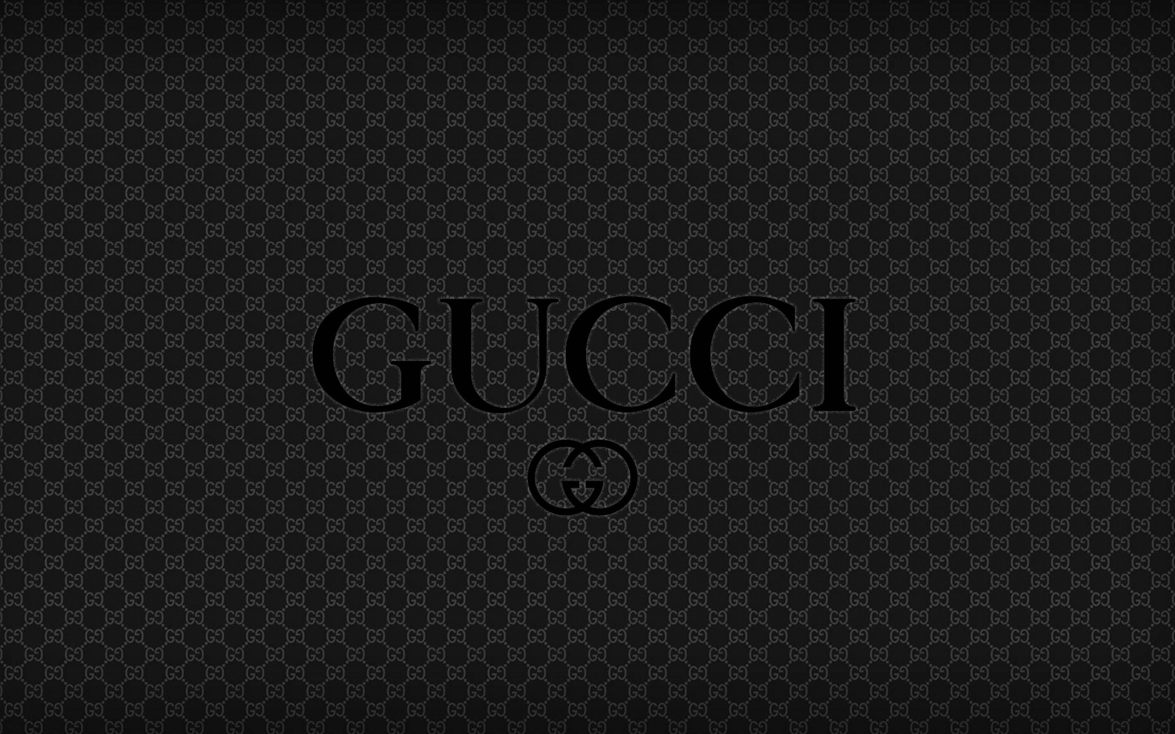 Gucci 桌布 壁紙 — 黑色Gucci桌布，品牌名稱和標誌居中於重複的字母組合圖案上。