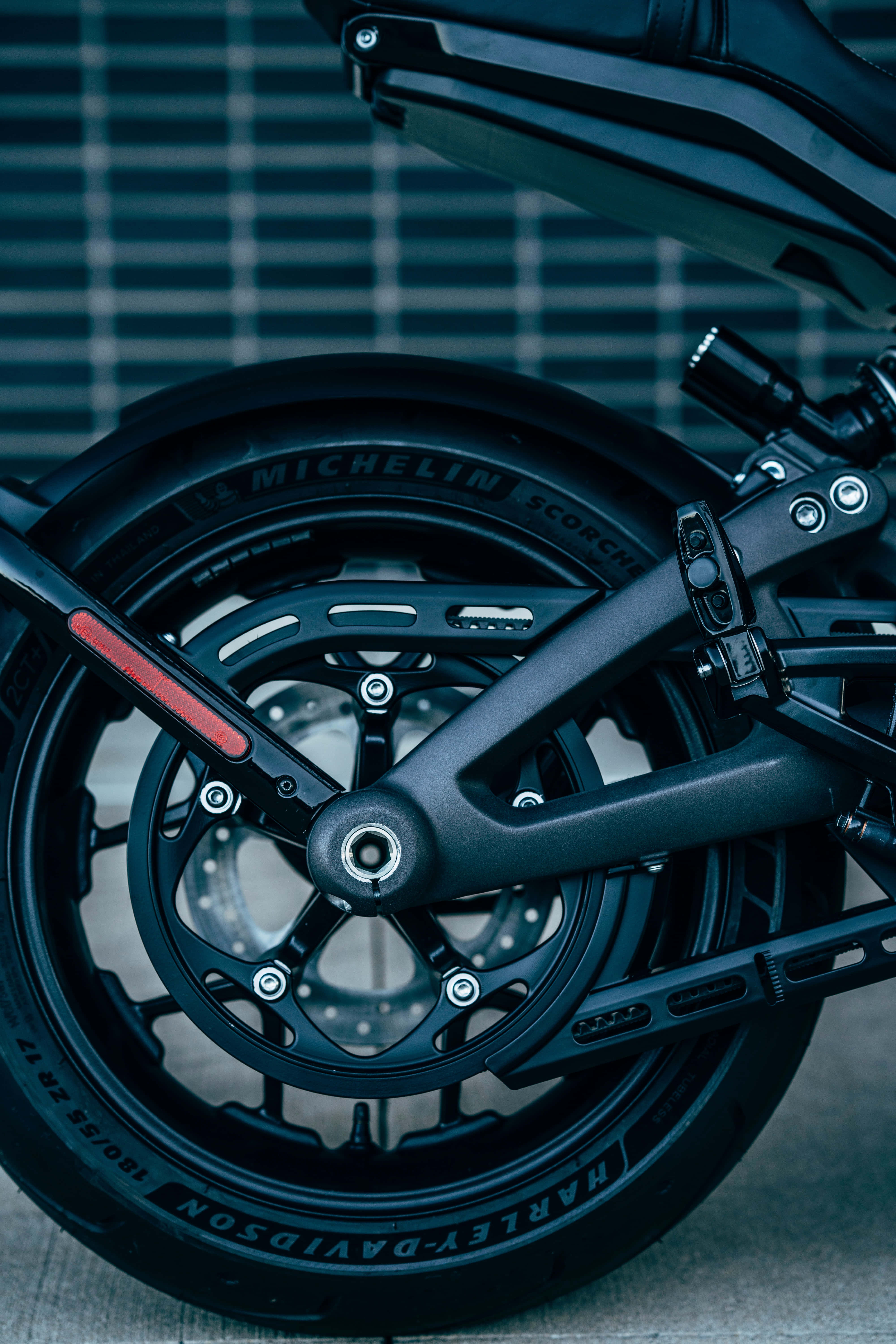 Motorcycle iPhone 桌布 壁紙 — 黑色Harley-Davidson機車車輪配米其林輪胎，藍色網格背景特寫。
