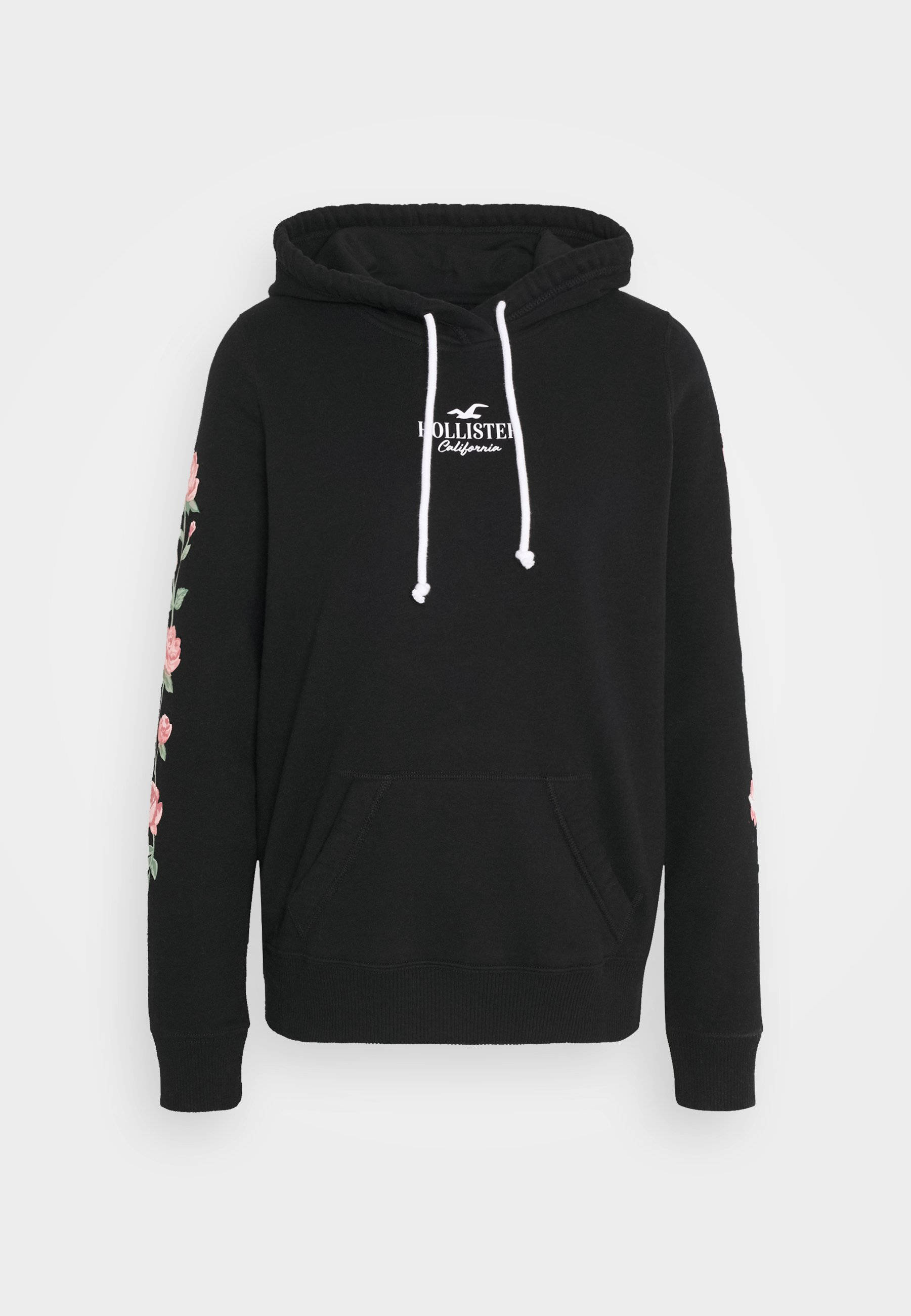 Hollister 桌布 壁紙 — 黑色Hollister連帽衛衣，白色抽繩，袖子上有粉紅色花卉刺繡，背景簡潔。