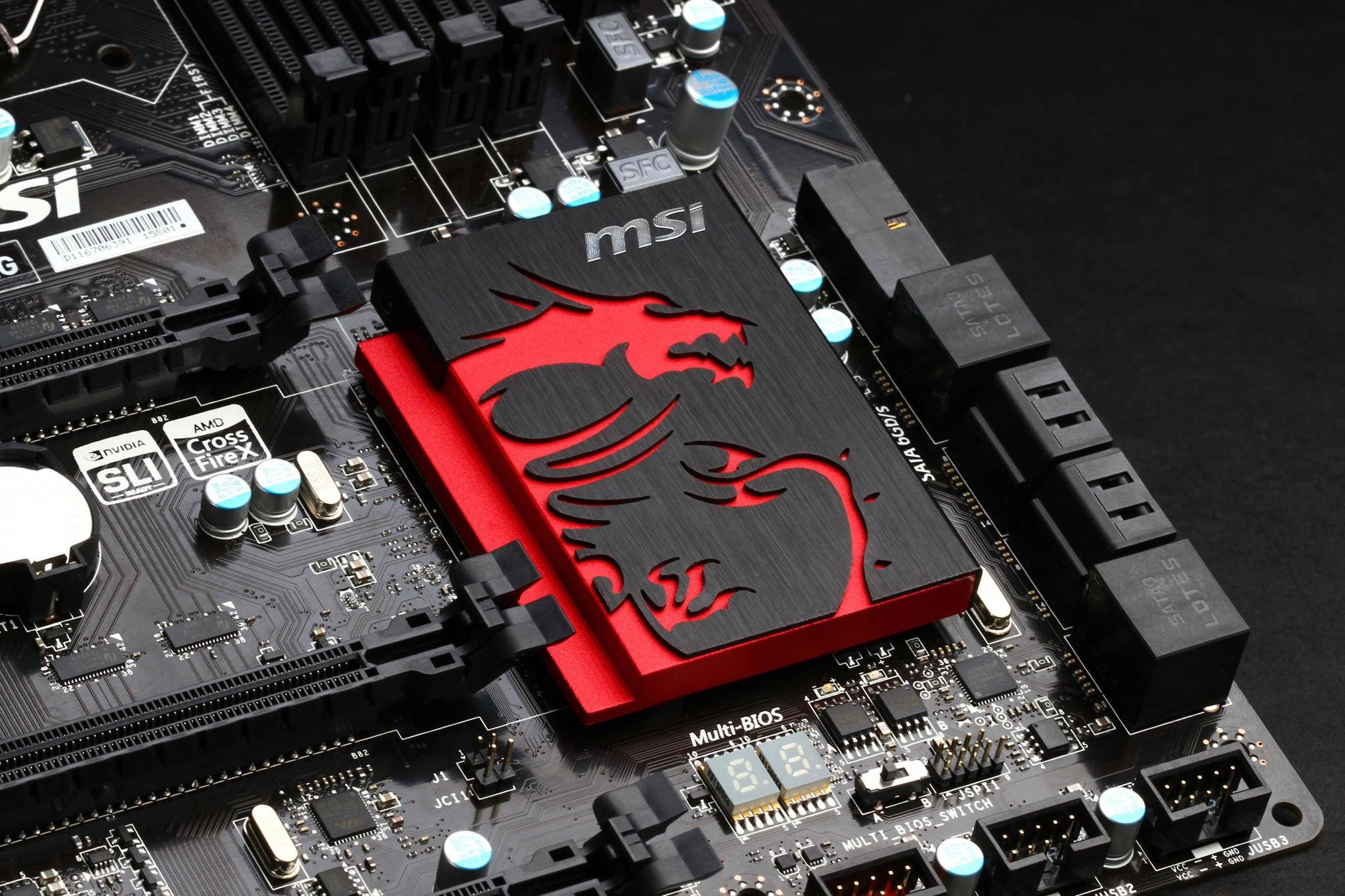 Msi Gaming 桌布 壁紙 — 黑色MSI主機板特寫，帶有紅色龍標誌散熱器和發光藍色電容。