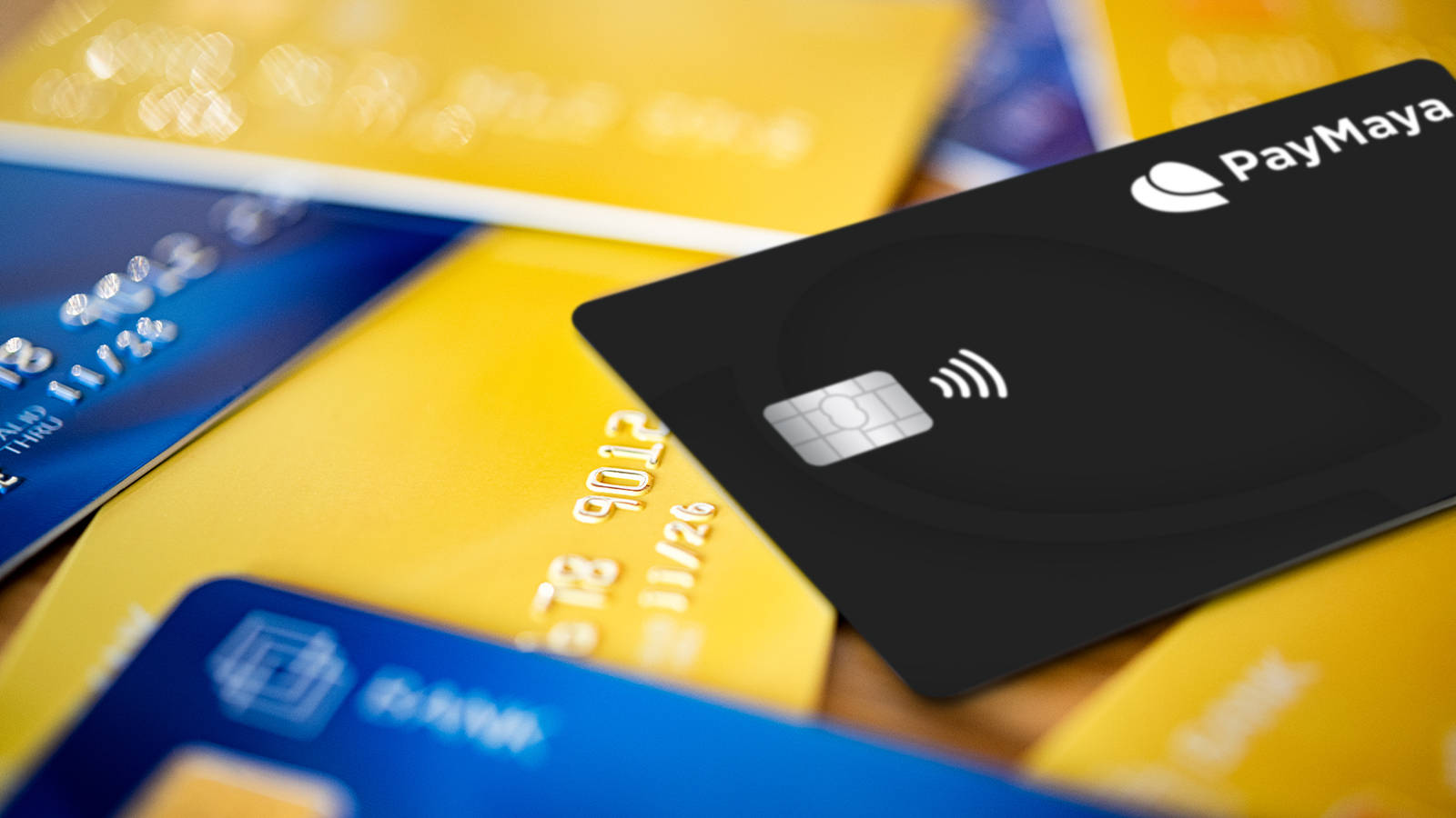 Credit Card 桌布 壁紙 — 黑色PayMaya卡帶非接觸式符號的特寫，放在彩色信用卡上。