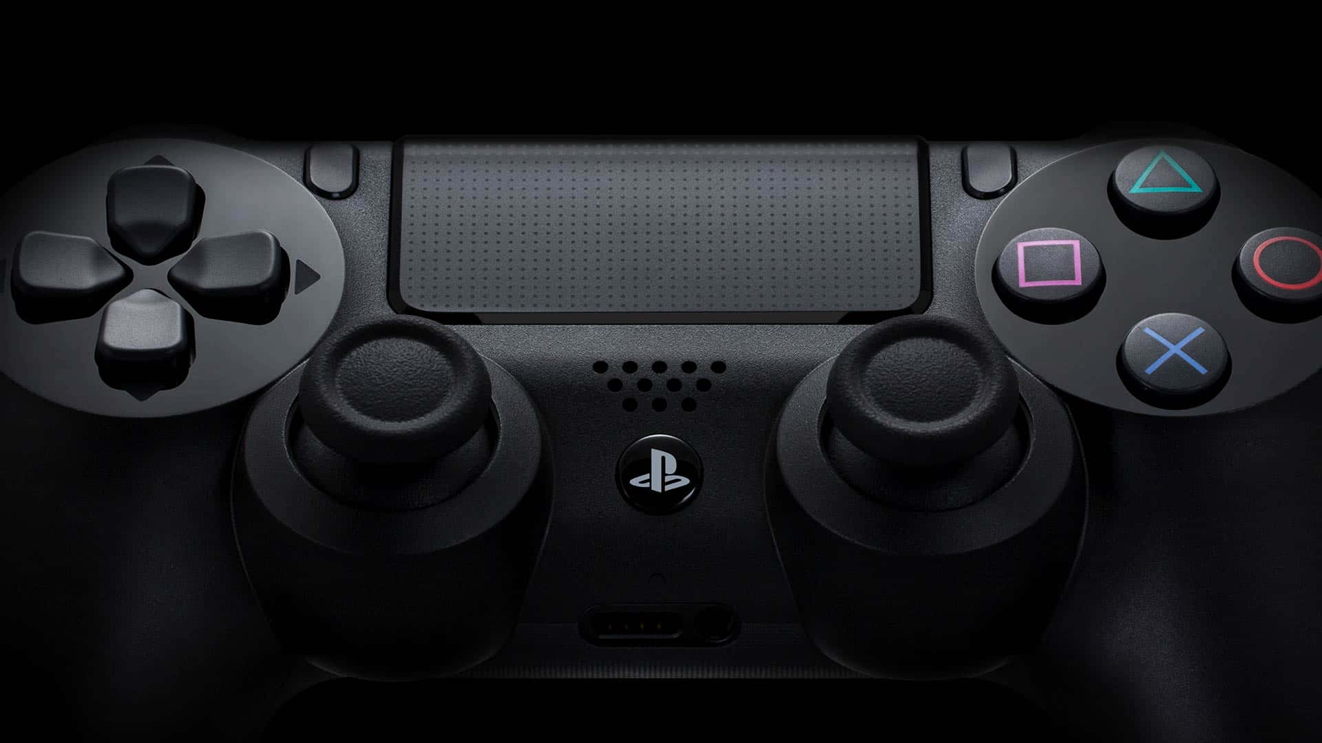 PlayStation 桌布 壁紙 — 黑色PlayStation手把特寫，帶有發光彩色按鈕，背景為深色。