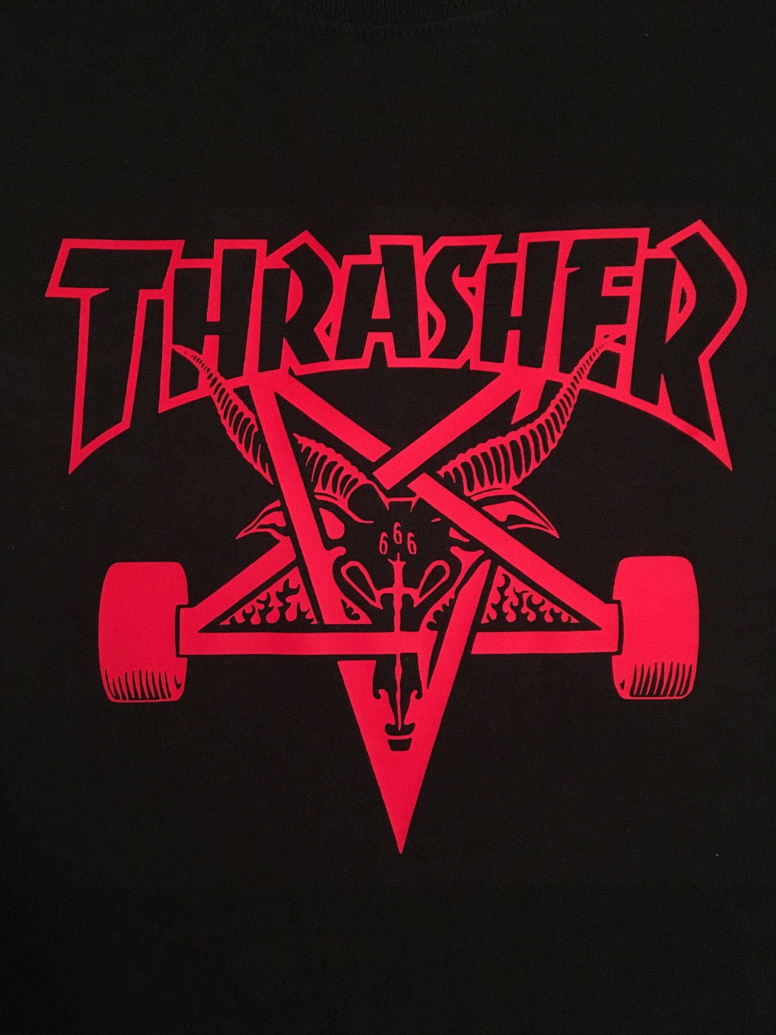 Thrasher 桌布 壁紙 — 黑色T恤上帶有山羊頭和輪胎的醒目紅色Thrasher標誌。