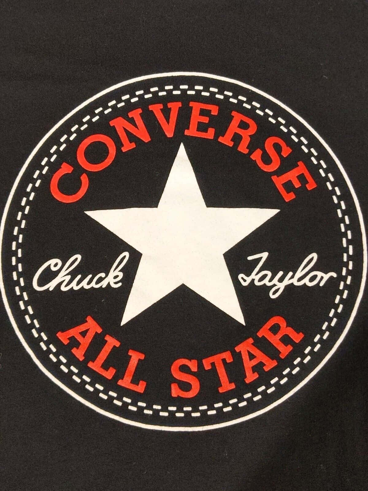 Converse 桌布 壁紙 — 黑色T恤特寫，帶有標誌性的紅白Converse Chuck Taylor All Star標誌，並有縫線圓形設計。