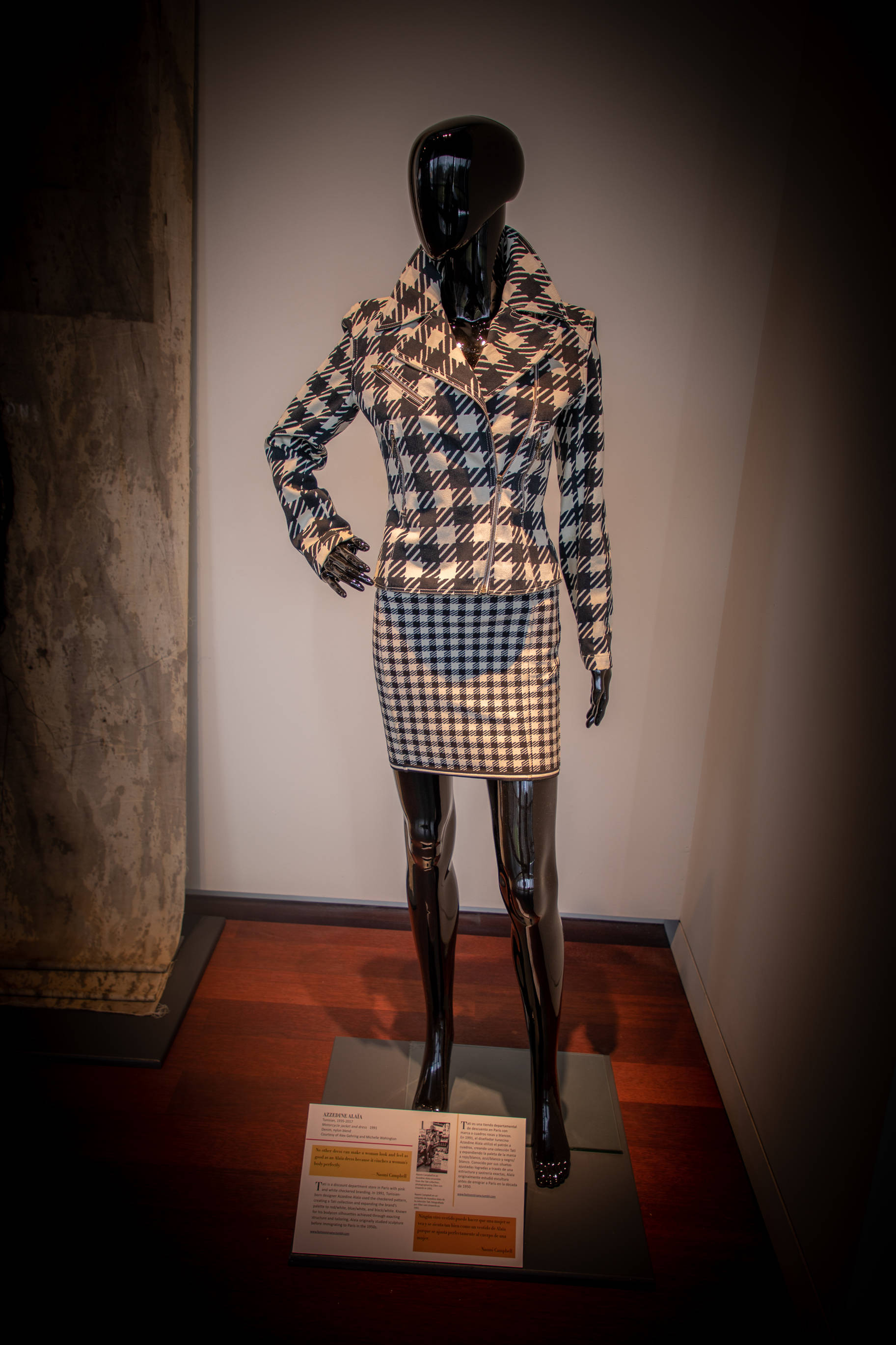 Plaid 桌布 壁紙 — 黑色人體模型在聚焦的畫廊燈光下展示千鳥格紋外套和裙子套裝。