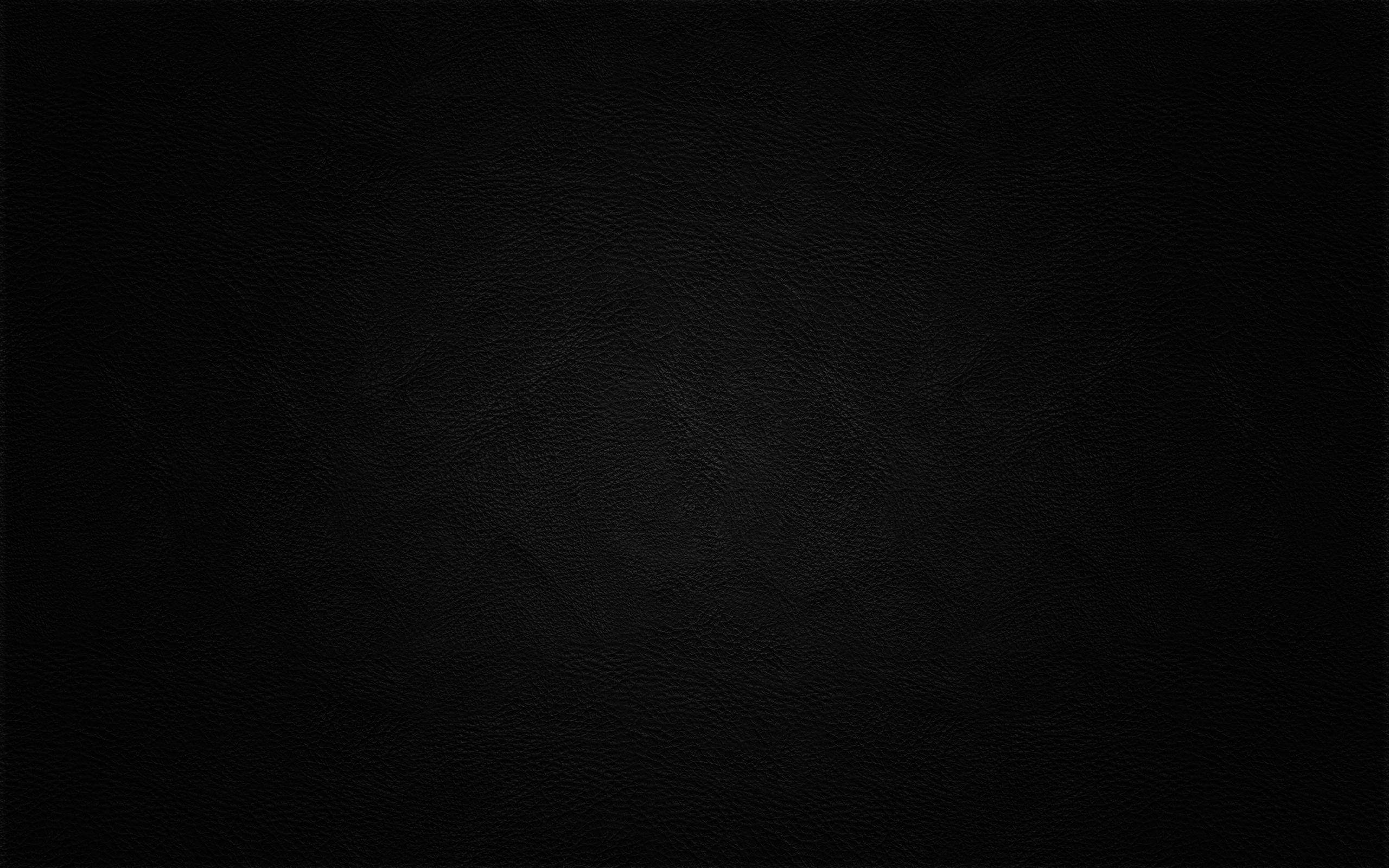 Plain Black 桌布 壁紙 — 黑色光滑皮革表面的特寫，帶有細微的粒面紋理和柔和的光線漸變。