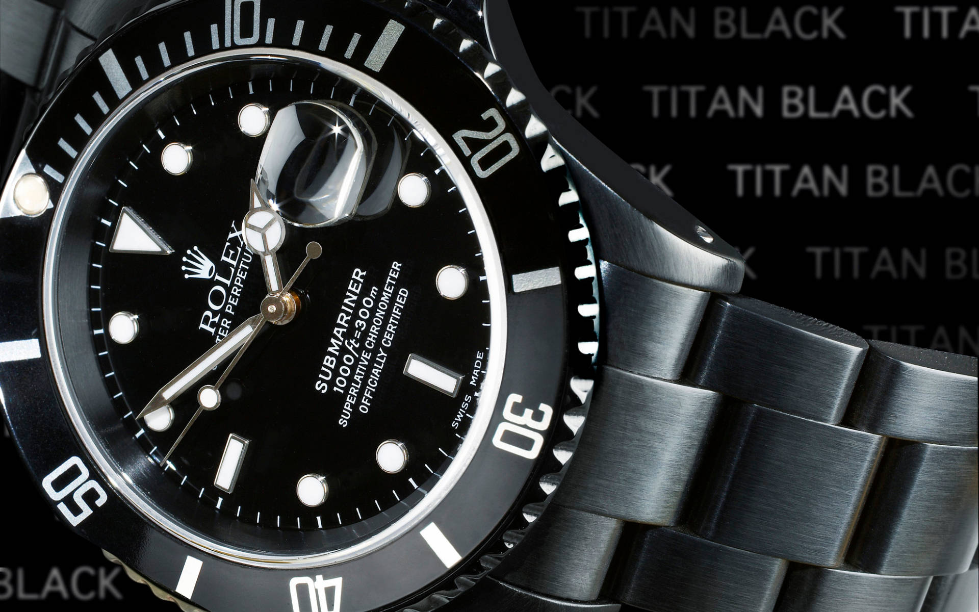 Rolex 桌布 壁紙 — 黑色勞力士潛航者型手錶特寫，配鈦金屬錶帶，背景為重複的「TITAN BLACK」圖案。