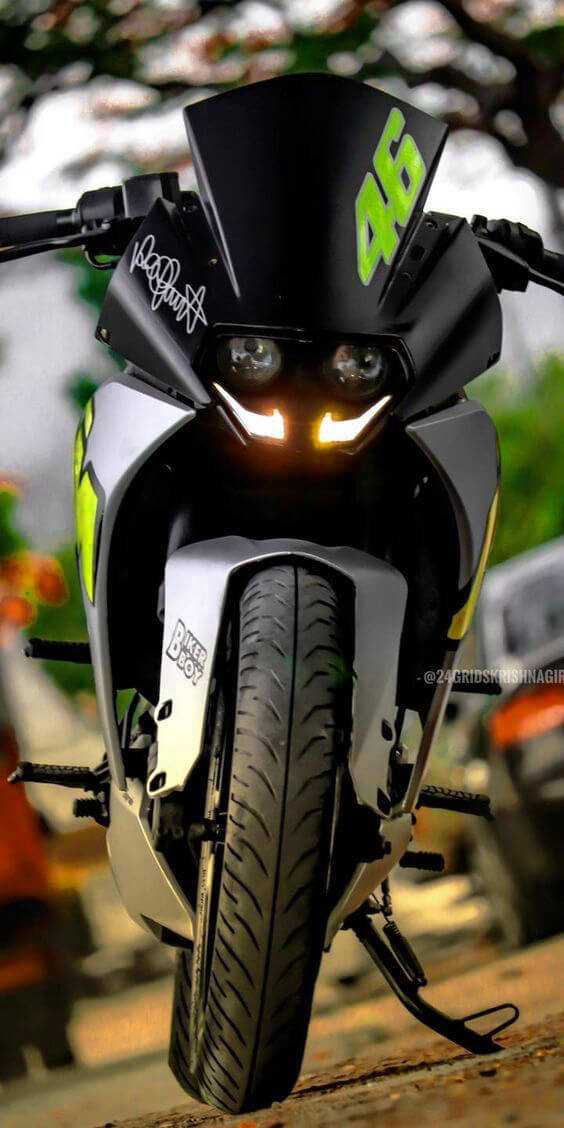 KTM RC 200 桌布 壁紙 — 黑色和螢光綠色的賽車機車特寫，車頭燈發光，停放在木質表面上。