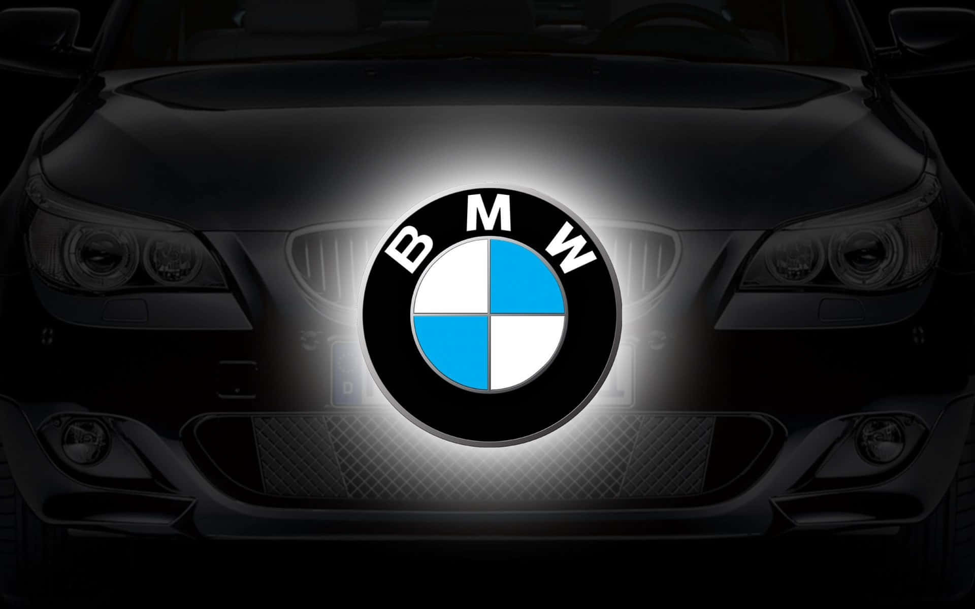 BMW 動圖 桌布 壁紙 — 黑色寶馬汽車的前進氣格柵在黑暗背景下閃耀著明亮的發光標誌。