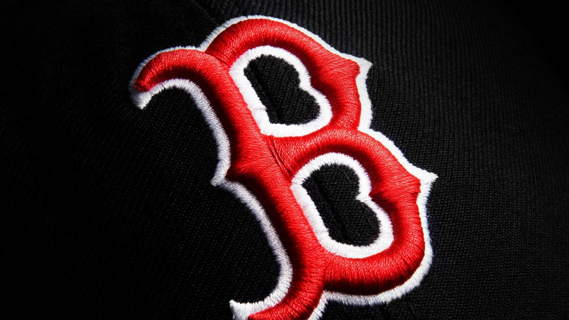 Boston Red Sox 桌布 壁紙 — 黑色布料上大膽的紅白刺繡「B」標誌特寫，可見縫線質感。