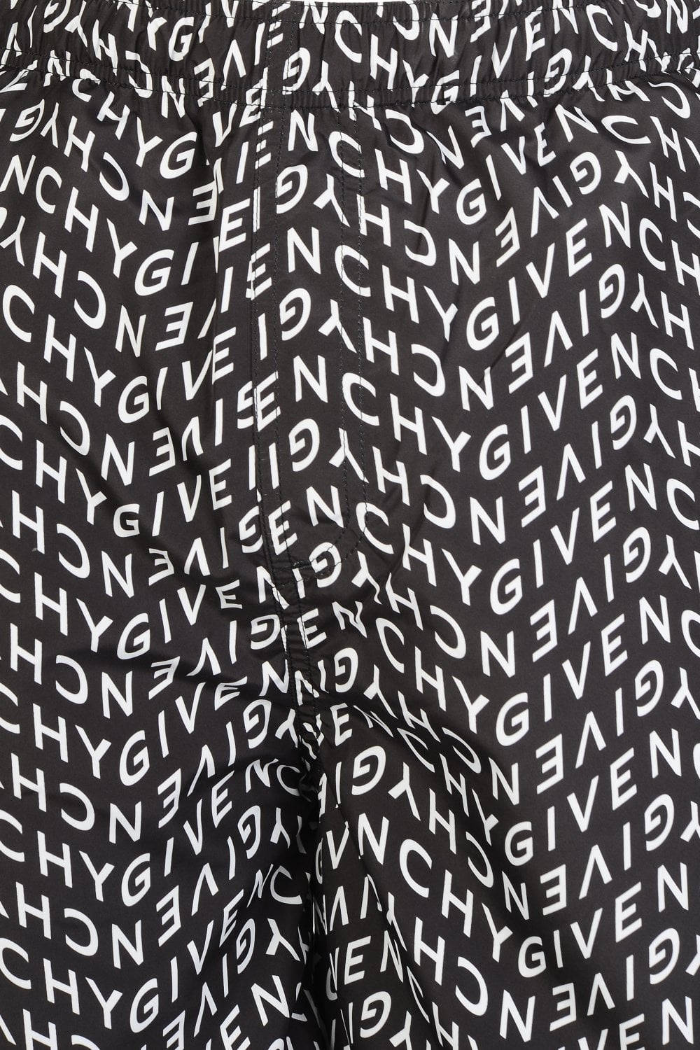 標誌 桌布 壁紙 — 黑色布料上重複白色「GIVENCHY」標誌的斜紋圖案特寫。