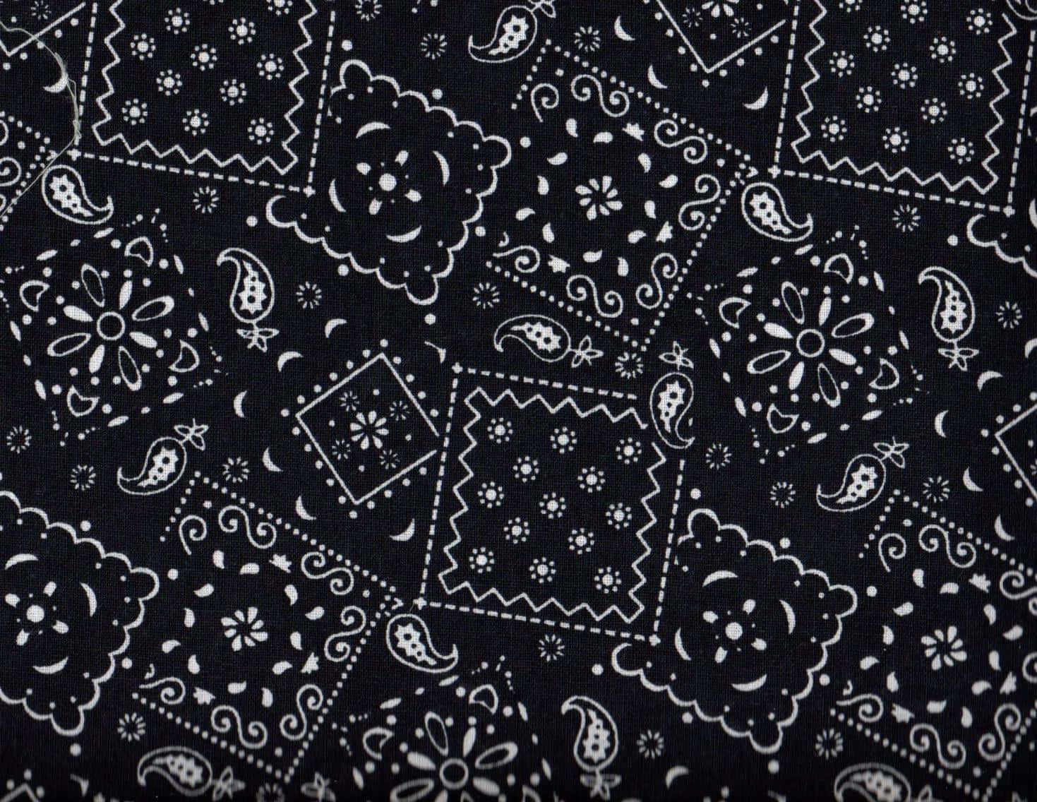 bandana 桌布 壁紙 — 黑色布料特寫，帶有複雜的白色佩斯利和花卉圖案，以重複的幾何區塊呈現。