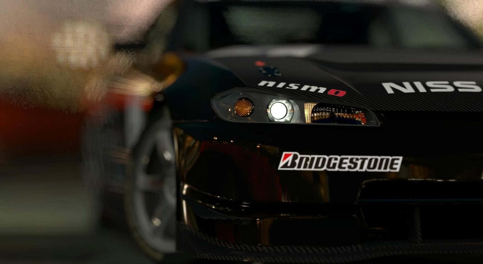跑車 桌布 壁紙 — 黑色日產Nismo賽車前端的特寫，帶有發光的頭燈和Bridgestone品牌標識。