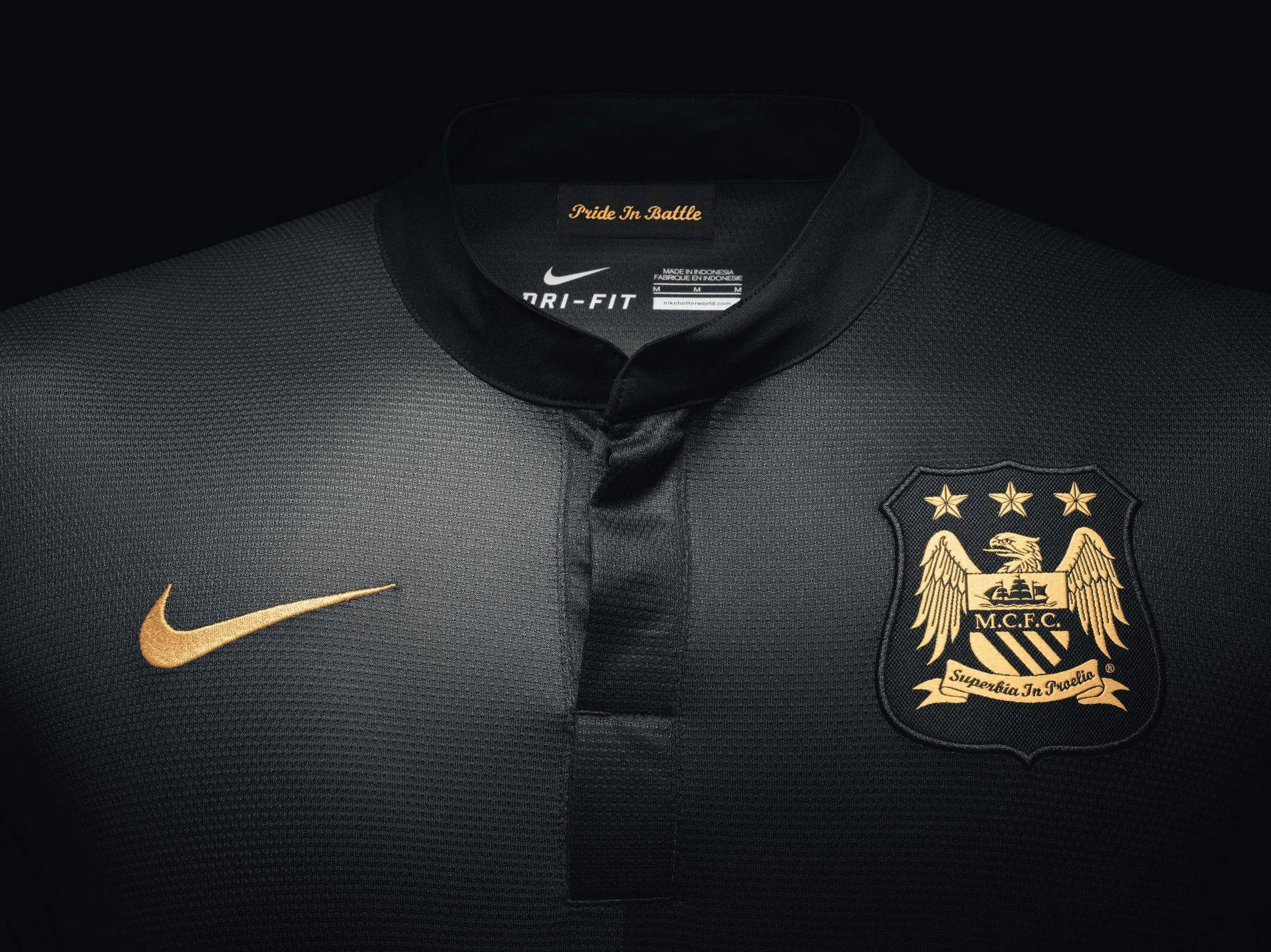 Nike 桌布 壁紙 — 黑色曼徹斯特城足球球衣特寫，帶有金色Nike勾勾和俱樂部徽章，背景為深色。