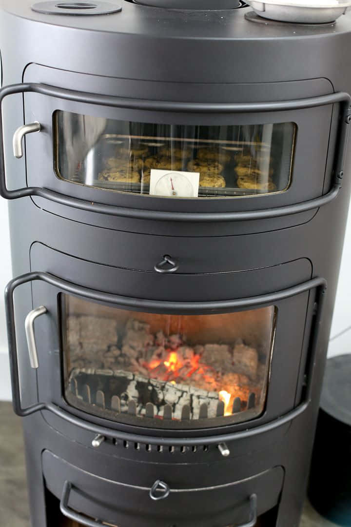 Stove 桌布 壁紙 — 黑色柴火爐的特寫，透過玻璃門可以看到發光的餘燼和木柴。