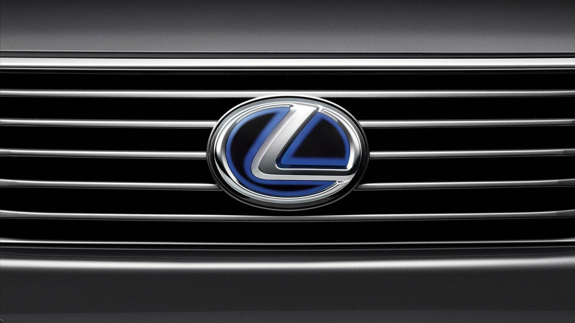 Lexus 標誌 桌布 壁紙 — 黑色格柵上帶有鍍鉻裝飾的凌志標誌發出藍光的特寫。