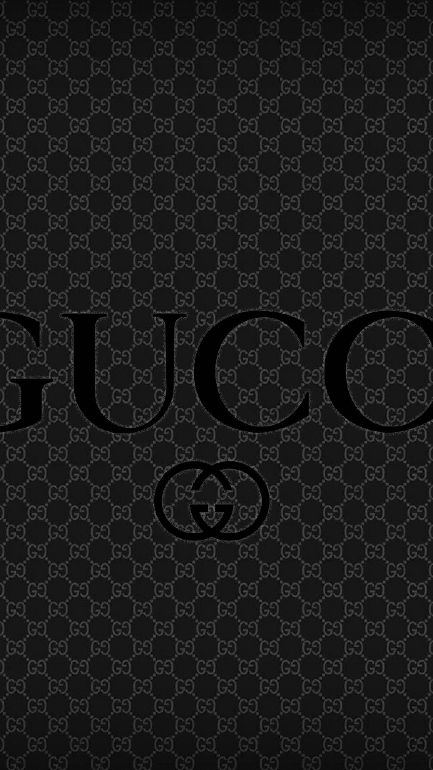 Gucci 桌布 壁紙 — 黑色桌布，帶有重複的Gucci標誌圖案，包括大膽的Gucci文字和交織的G標誌。