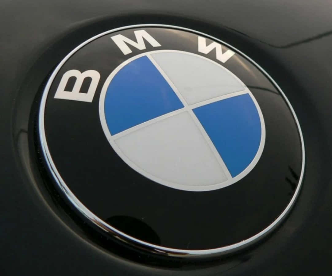 Bmw Logo 桌布 壁紙 — 黑色汽車表面上帶有藍白四象限的光澤BMW標誌特寫。