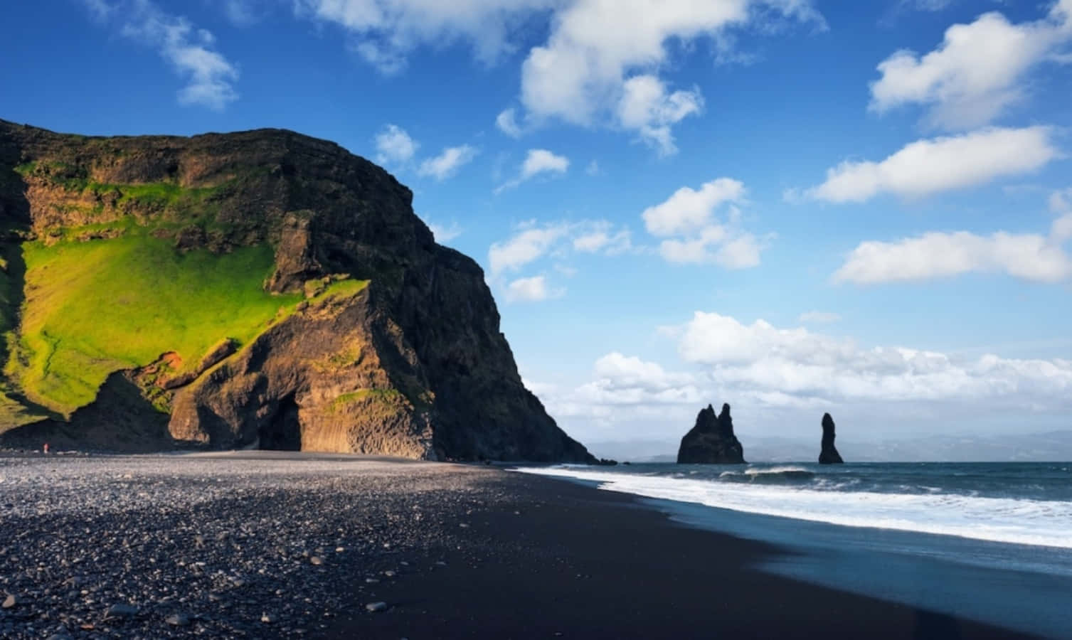 Black Sand Beach 桌布 壁紙 — 黑色沙灘遇上碧綠海浪，在藍天白雲和綠色懸崖下。