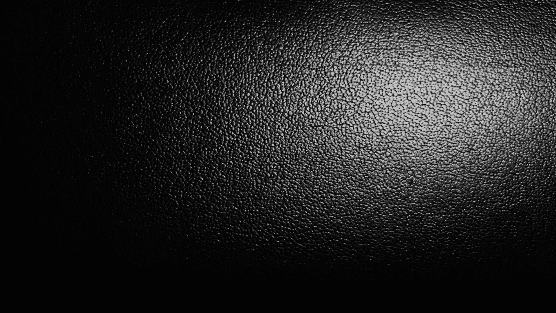 Leather 桌布 壁紙 — 黑色皮革紋理特寫，柔和漸變燈光突顯粒面表面。