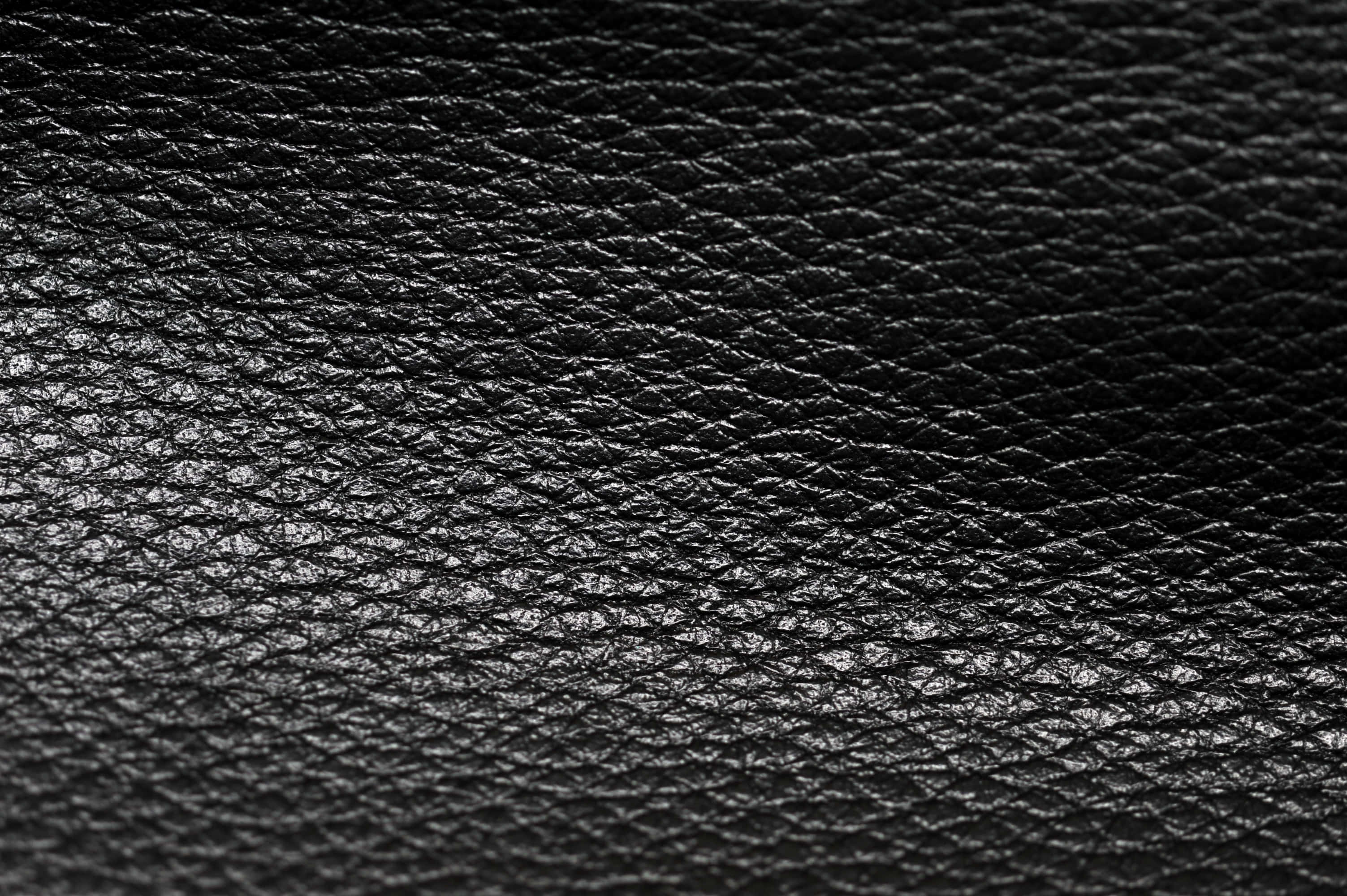 Black Leather 桌布 壁紙 — 黑色皮革質感特寫，在柔和光線下呈現細微光澤和天然紋理。