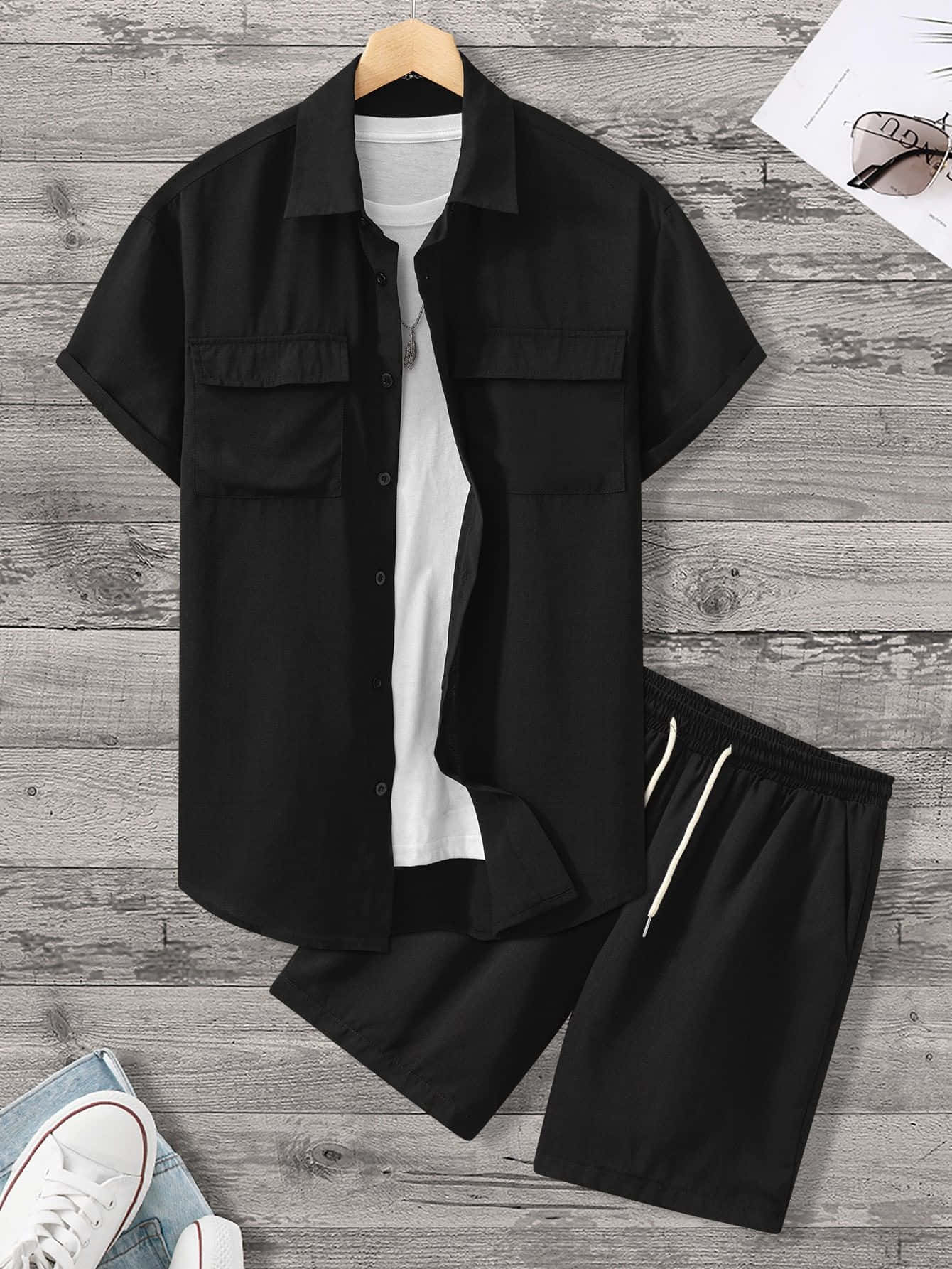 Black Clothing 桌布 壁紙 — 黑色短袖襯衫和短褲套裝在木地板上造型，附近有白色運動鞋和太陽眼鏡。