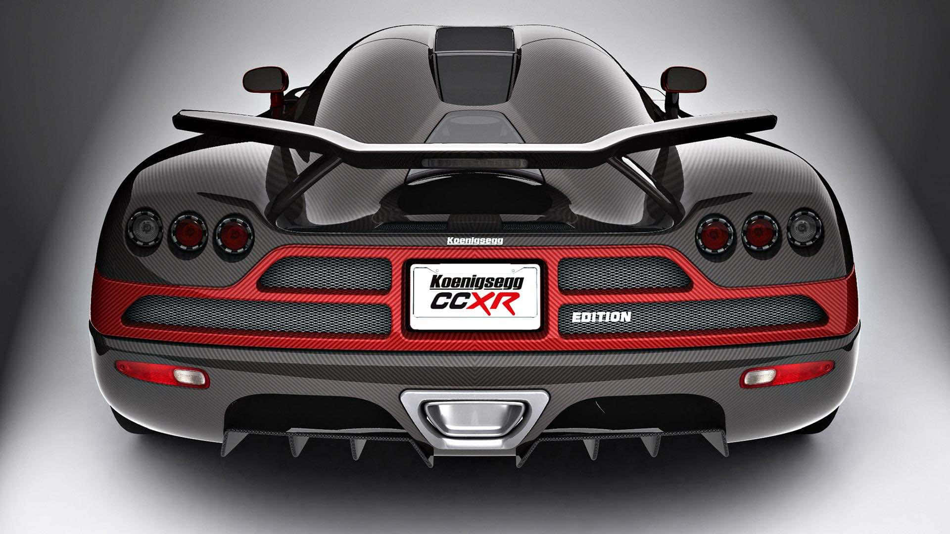 高清汽車 桌布 壁紙 — 黑色碳纖維 Koenigsegg CCXR Edition 超級跑車的後視圖，帶有紅色點綴和大型後尾翼。