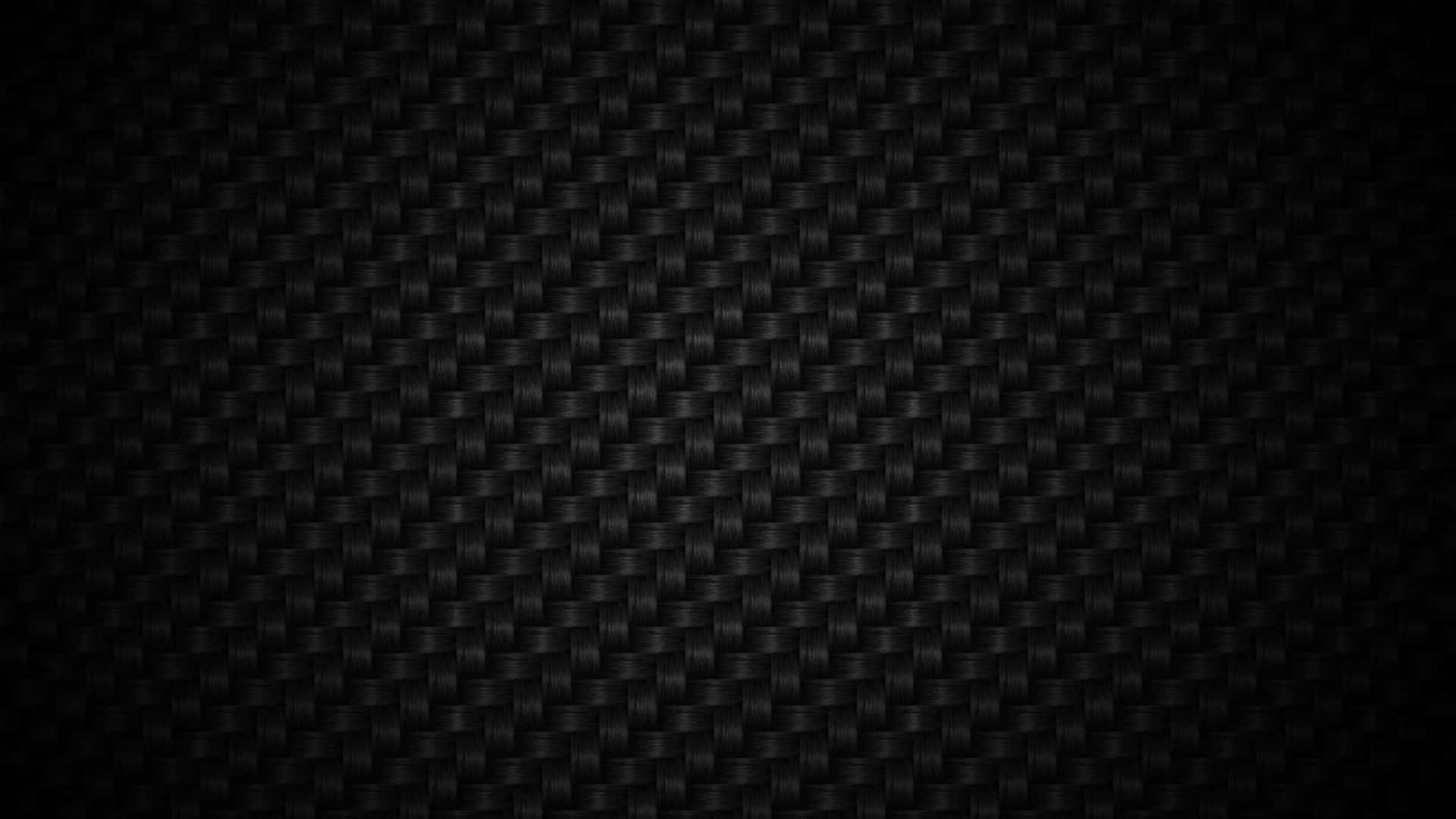 Black Zoom 桌布 壁紙 — 黑色碳纖維質感的特寫，帶有細膩的編織圖案和漸變燈光。