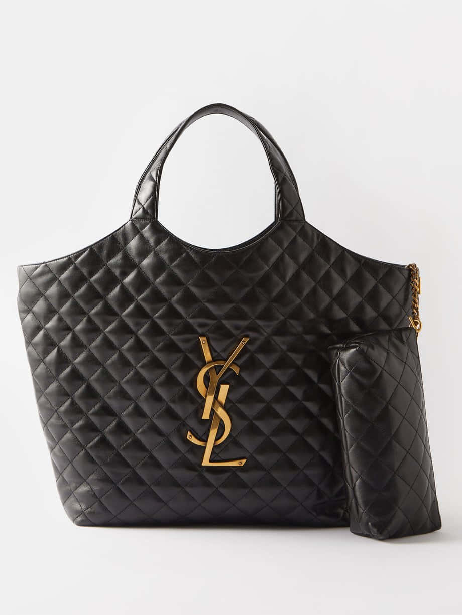 Ysl 桌布 壁紙 — 黑色絎縫皮革YSL托特包，帶金色標誌和鏈條肩帶，白色背景。