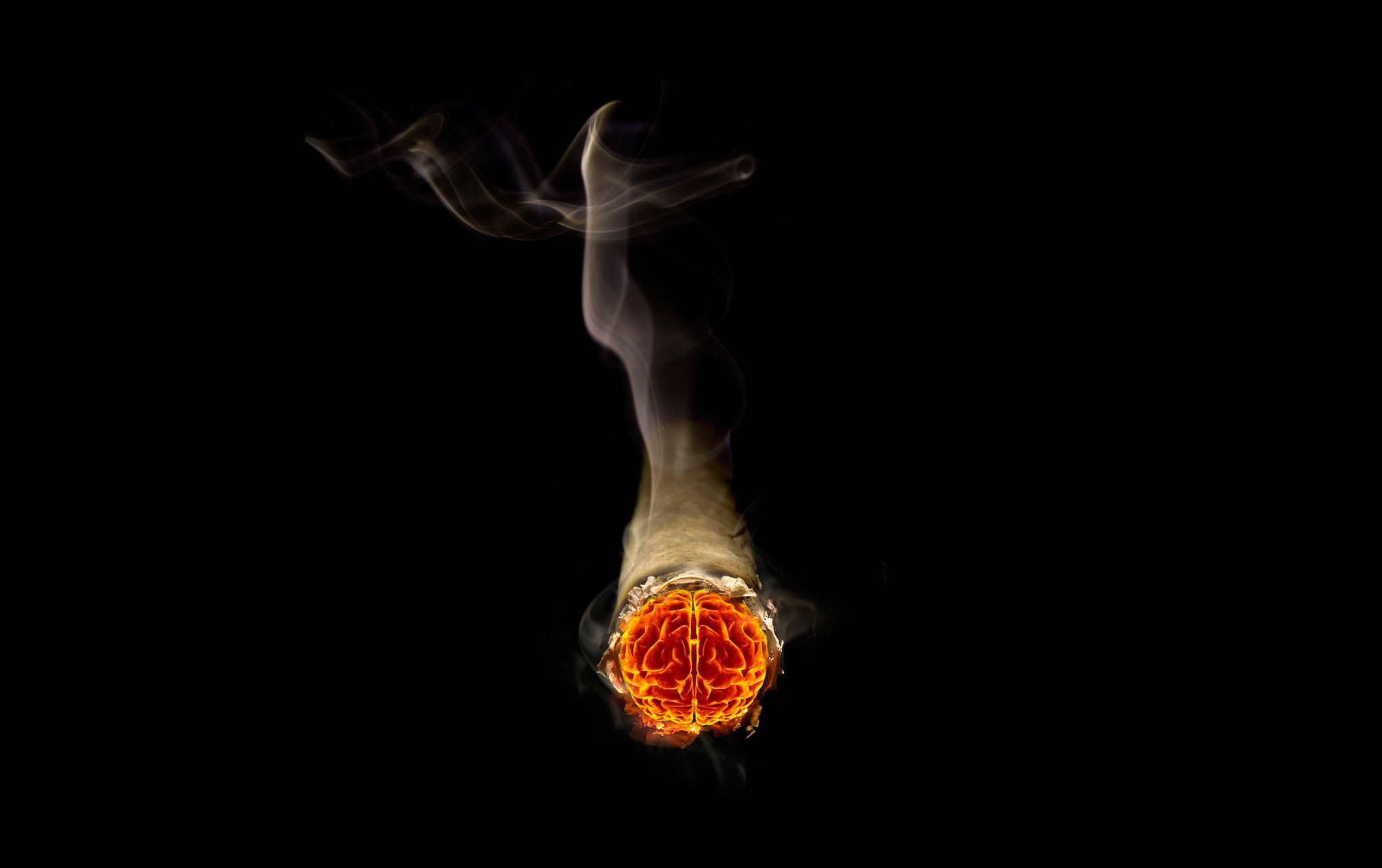 Smoking 桌布 壁紙 — 黑色背景上，一根冒煙的香煙底部有一個發光的大腦。