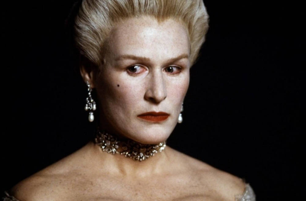 電影動圖 桌布 壁紙 — 黑色背景上，葛倫·克蘿絲（Glenn Close）的頭部特寫，擁有鉑金色頭髮和紅唇。