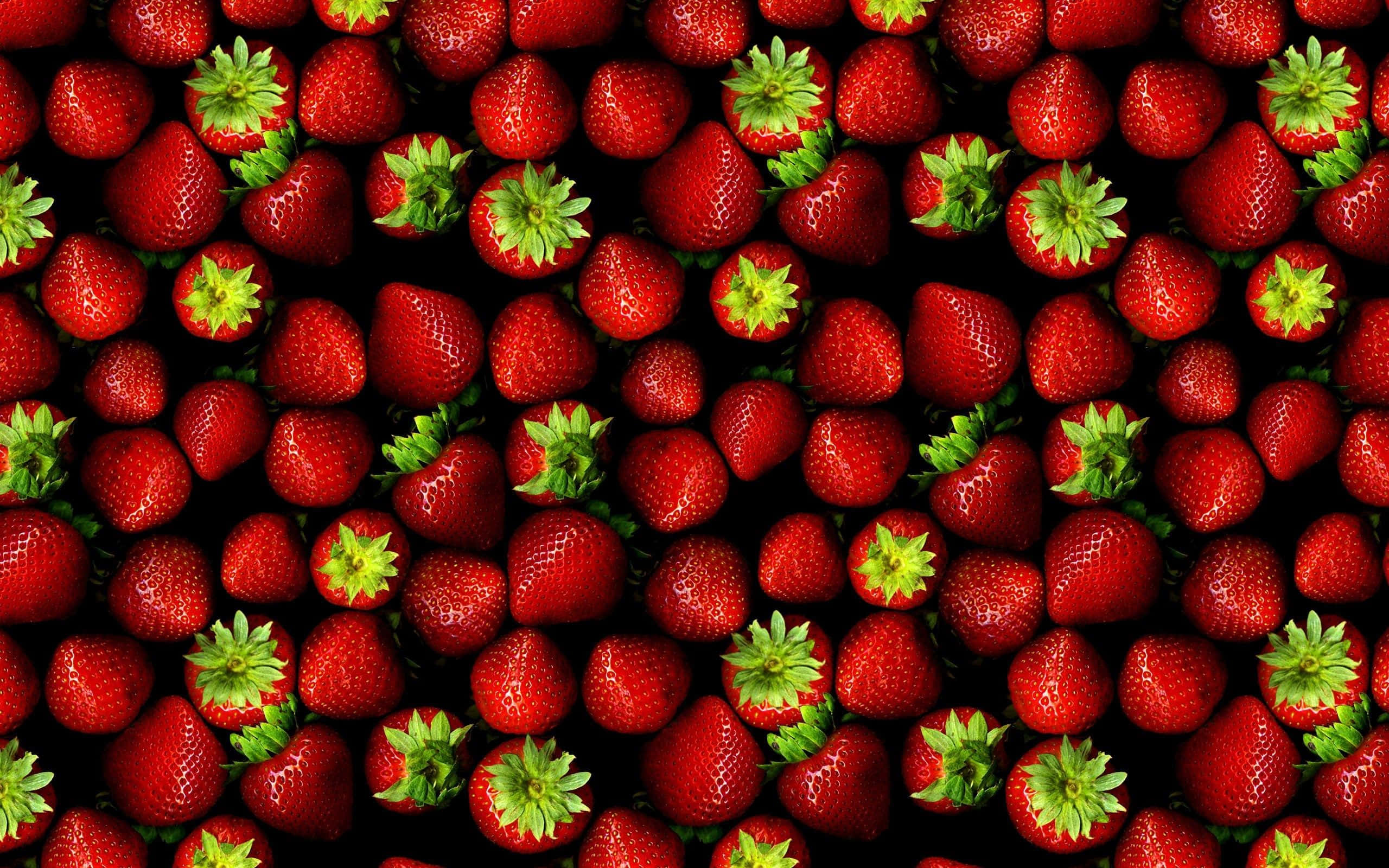 Red Strawberry 桌布 壁紙 — 黑色背景上，鮮紅色草莓與綠色頂部緊密特寫。