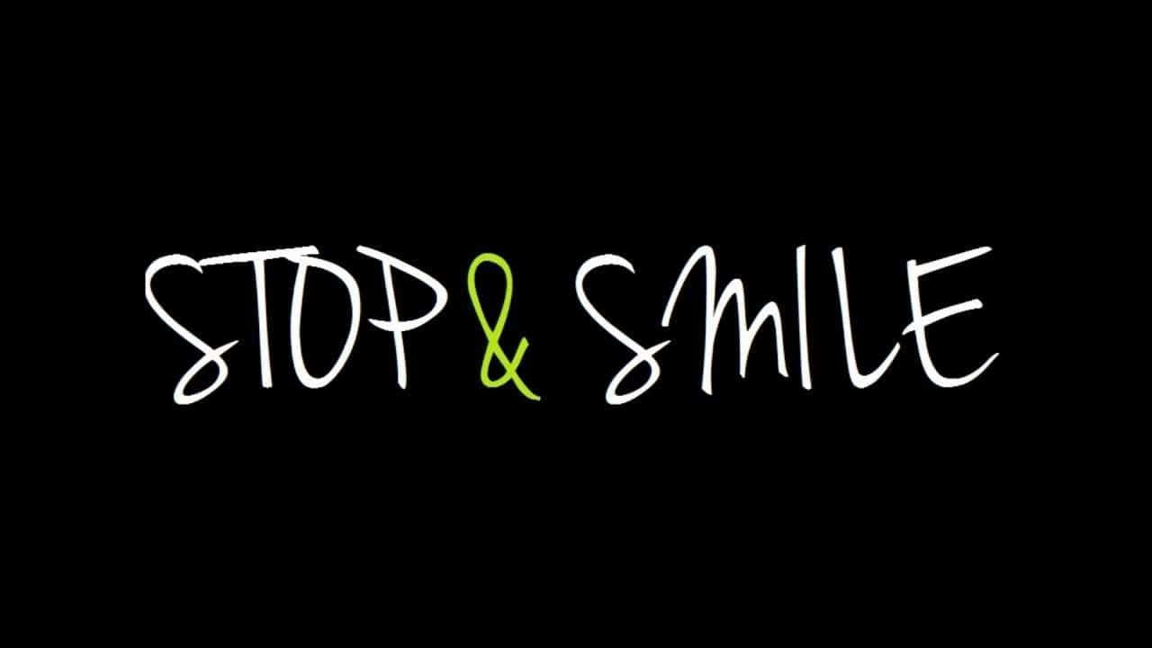 happiness 桌布 壁紙 — 黑色背景上以白色和綠色粗體手寫文字「STOP & SMILE」。