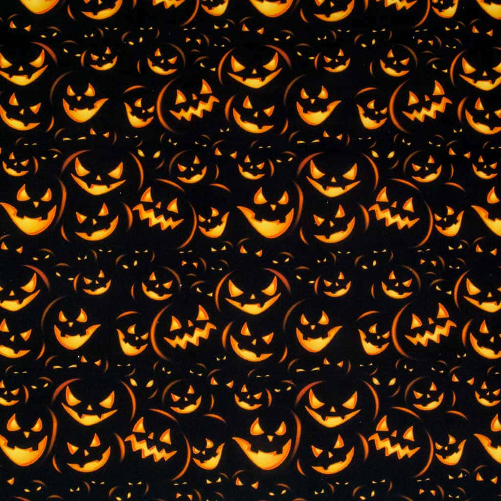 Halloween Pumpkin 桌布 壁紙 — 黑色背景上密集的發光橙色南瓜燈面孔，帶著兇惡的笑容。