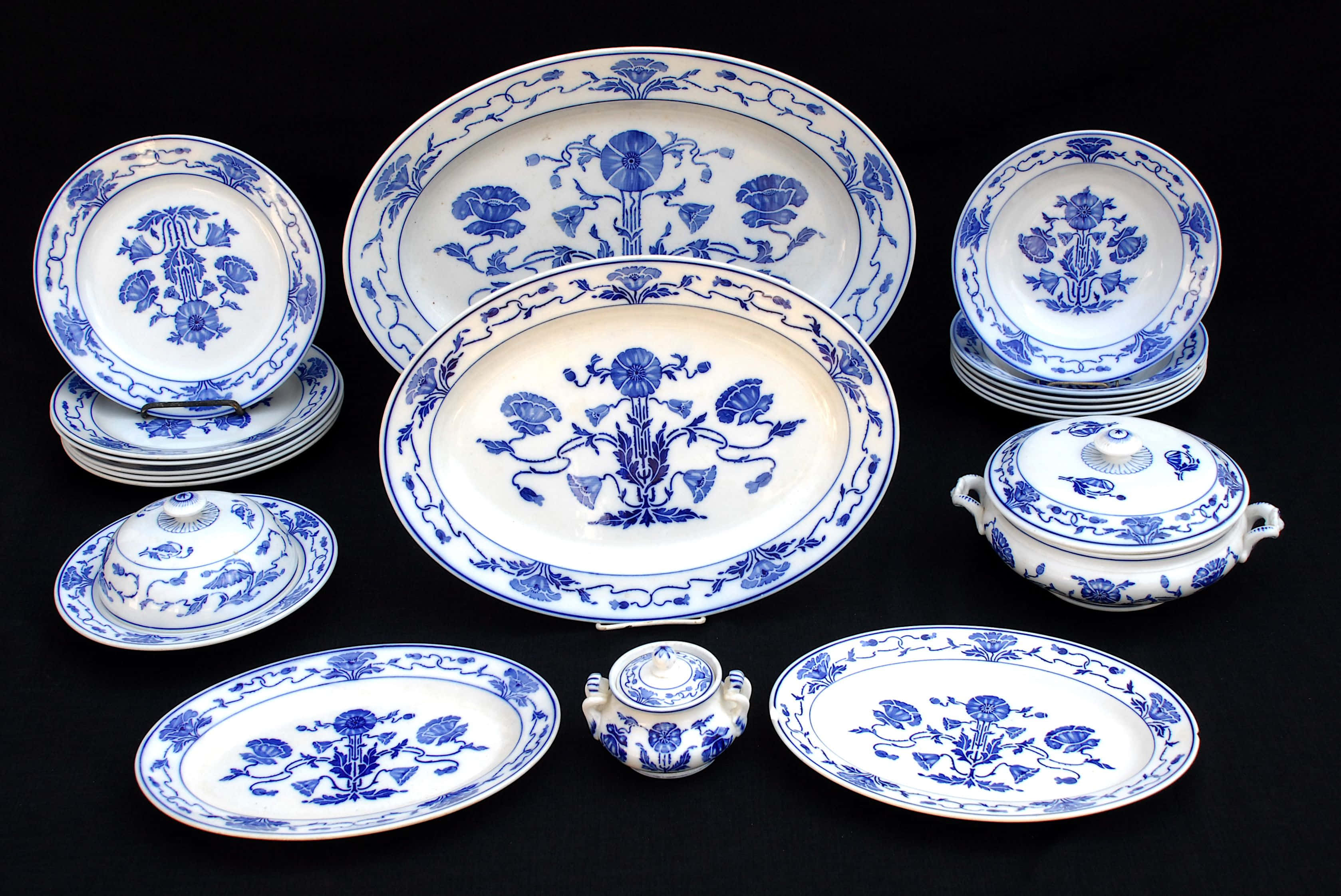 Ceramics 桌布 壁紙 — 黑色背景上展示的優雅藍白瓷器餐具套裝，帶有花卉圖案。