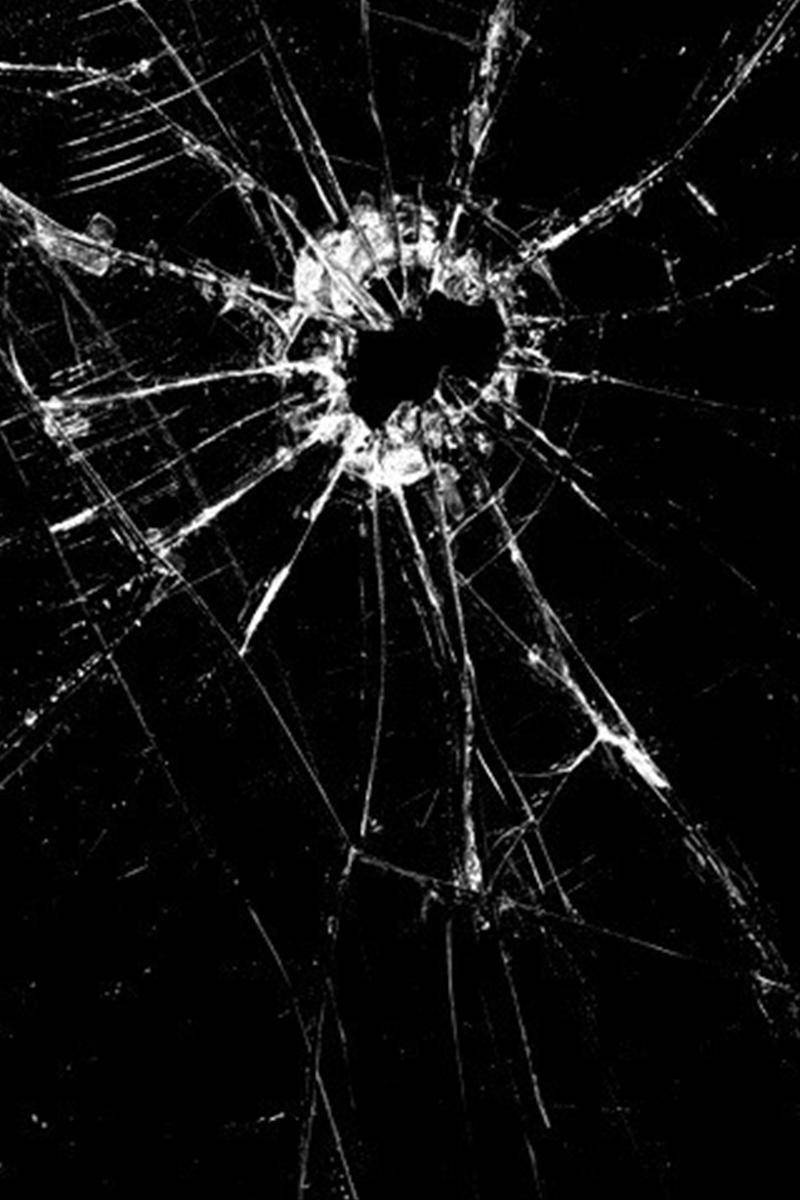 Screen 桌布 壁紙 — 黑色背景上帶有中心孔洞和放射狀裂紋的破碎玻璃表面。