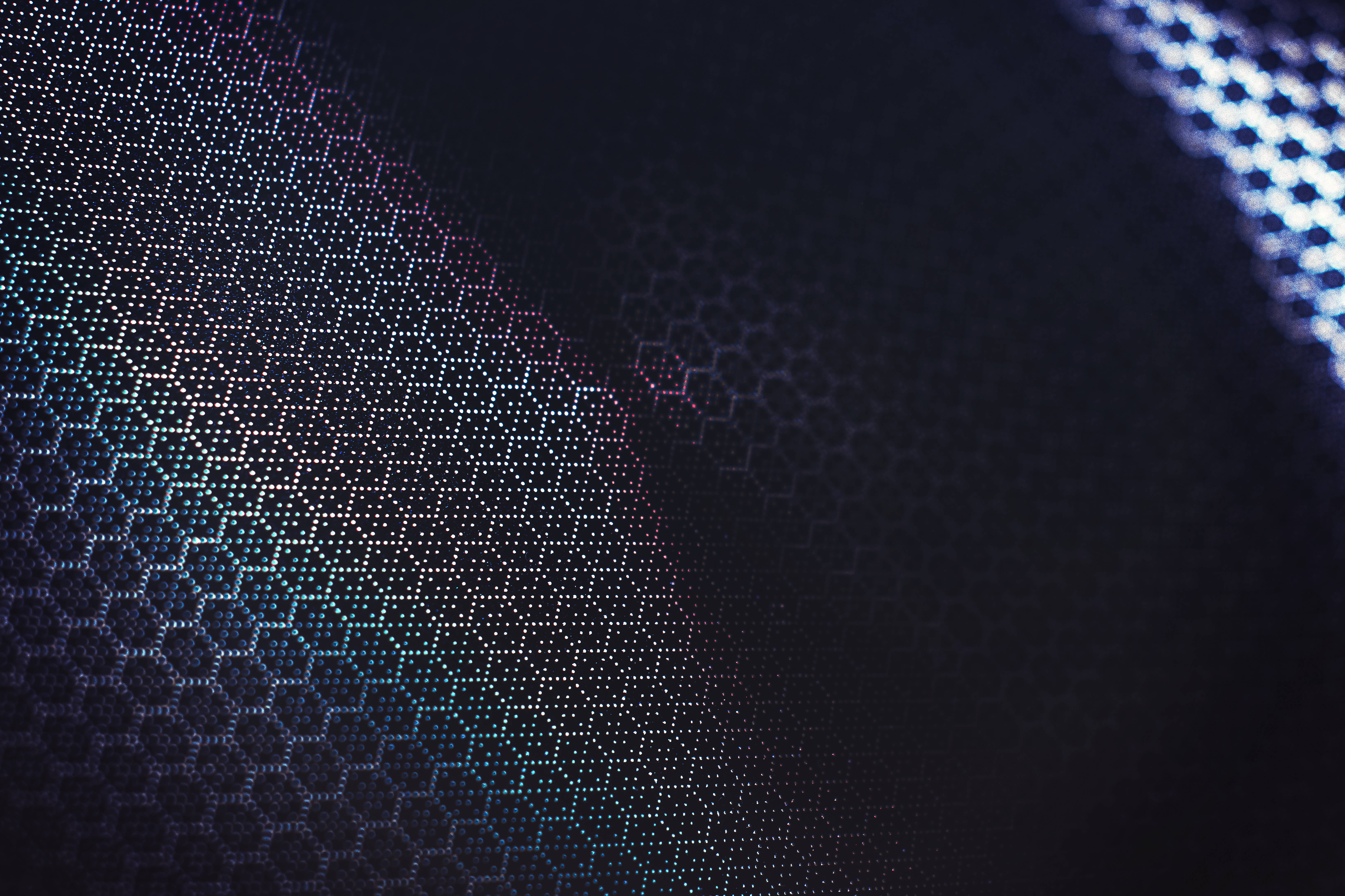 Honeycomb 桌布 壁紙 — 黑色背景上帶有藍色和紫色發光點的深色六邊形網格圖案特寫。