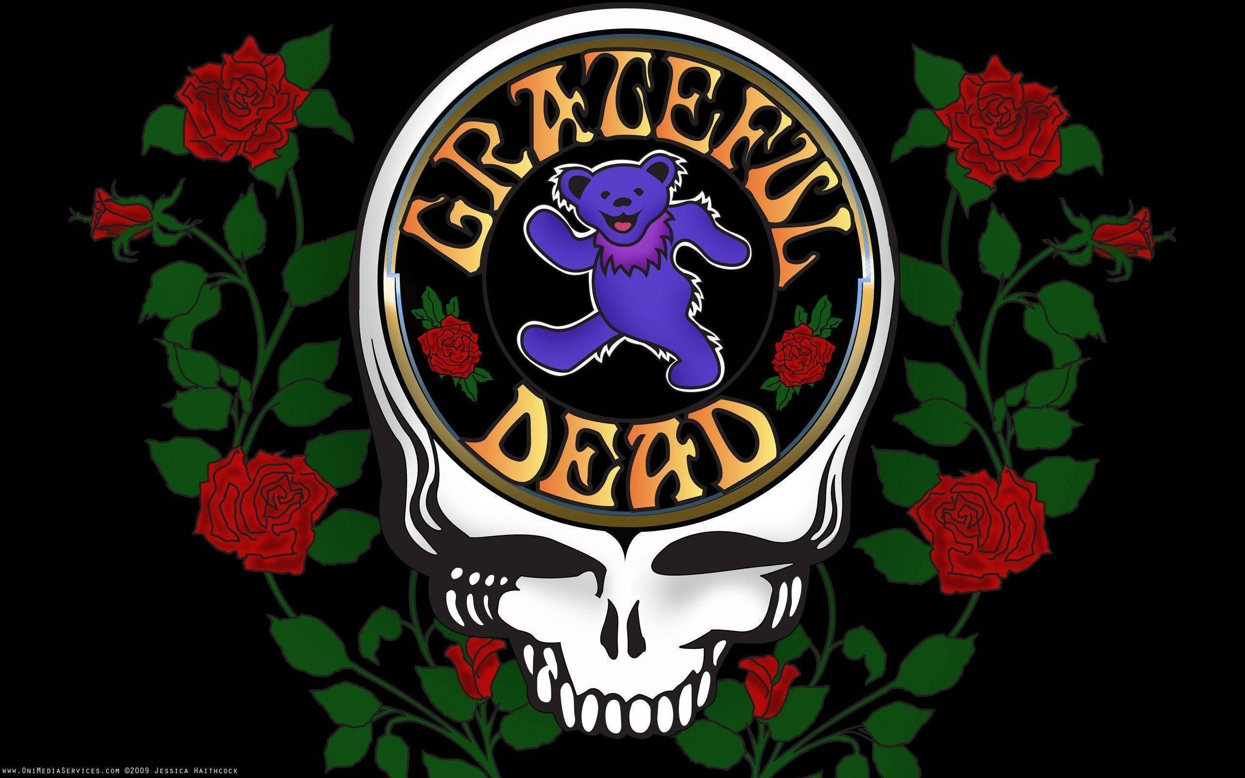 dead 桌布 壁紙 — 黑色背景上有一個白色骷髏頭，內有紫色跳舞熊和「Grateful Dead」文字，周圍環繞著紅玫瑰和綠色藤蔓。