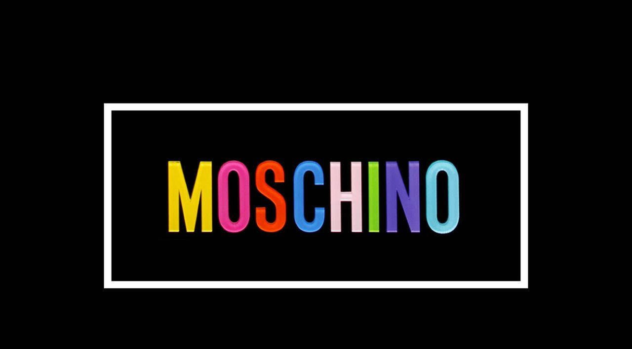 moschino 桌布 壁紙 — 黑色背景上的白色長方形內，彩虹色粗體字母「MOSCHINO」居中排列。