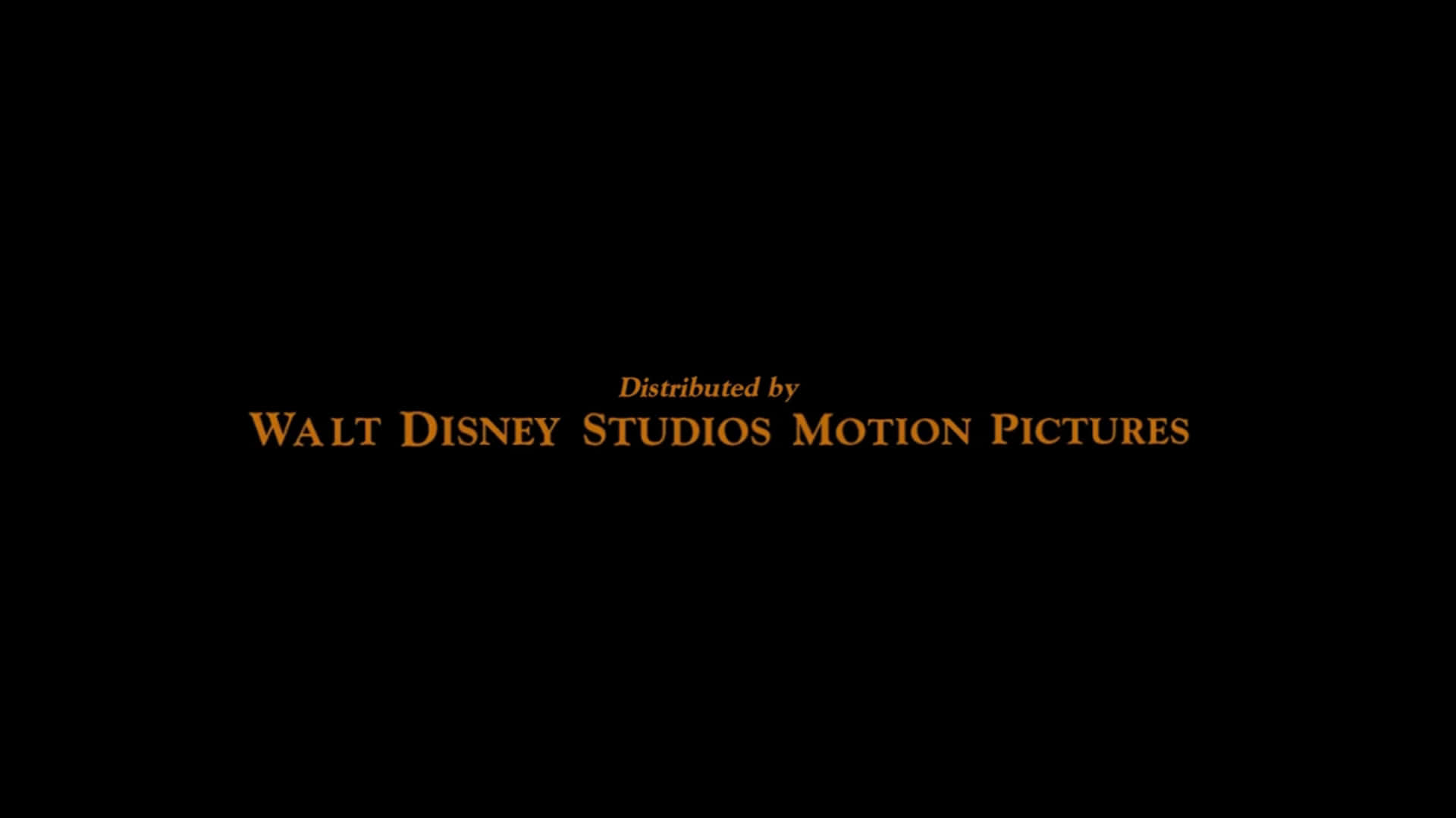 Walt Disney Studios Motion 桌布 壁紙 — 黑色背景上的金色文字以經典迪士尼字體寫著「Distributed by WALT DISNEY STUDIOS MOTION PICTURES」。