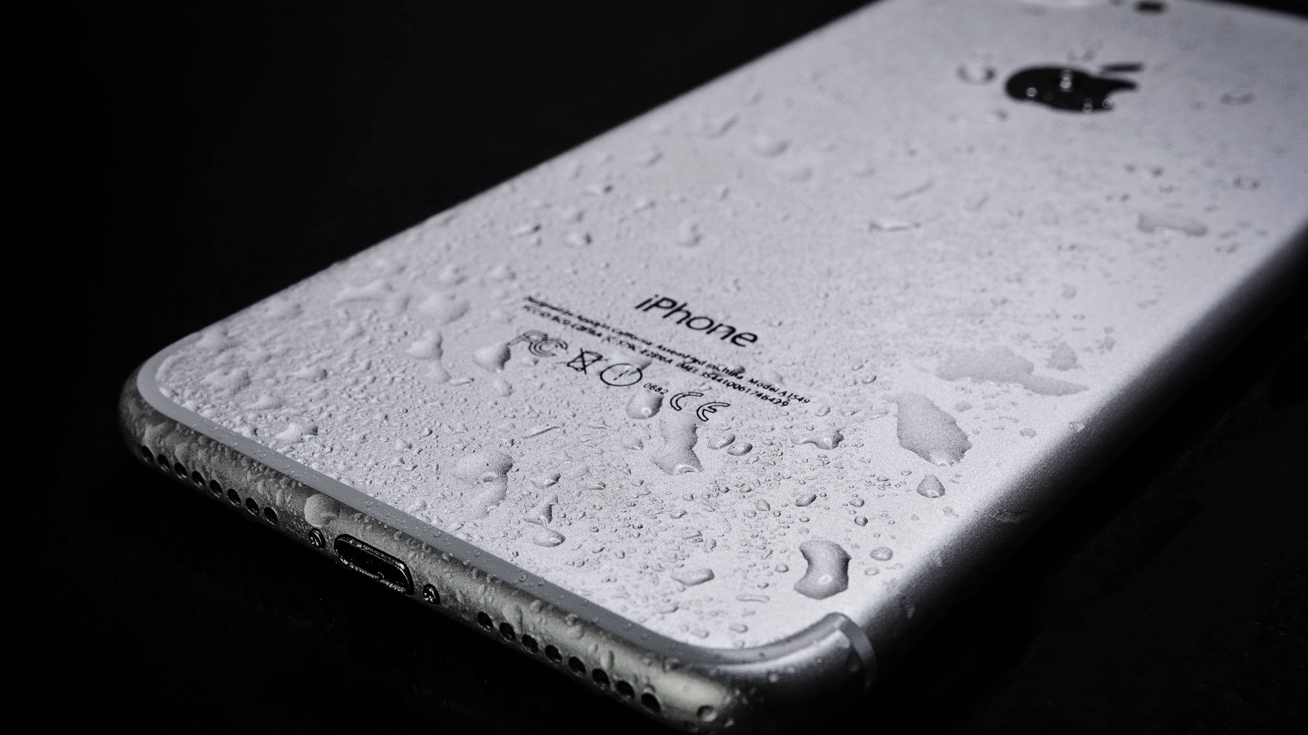 Silver 桌布 壁紙 — 黑色背景上覆蓋著水滴的銀色 iPhone 背面。