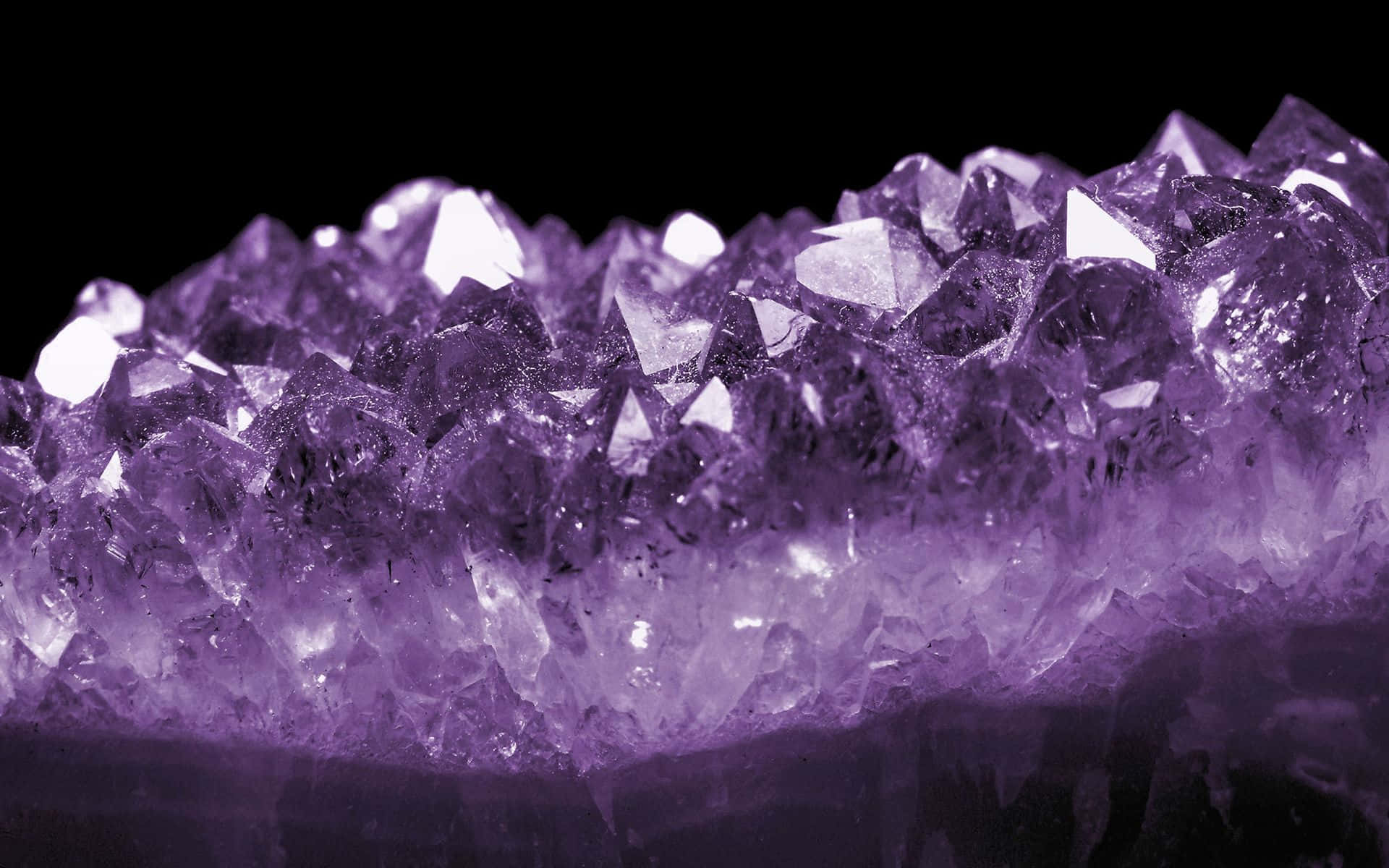 紫水晶 桌布 壁紙 — 黑色背景上閃閃發光的紫色紫水晶晶體的近距離特寫。