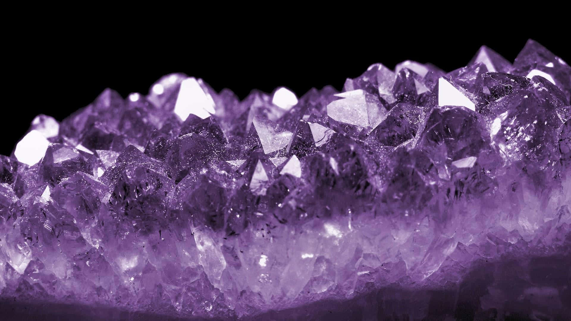 紫水晶 桌布 壁紙 — 黑色背景上閃閃發光的紫色紫水晶晶體的近距離特寫。