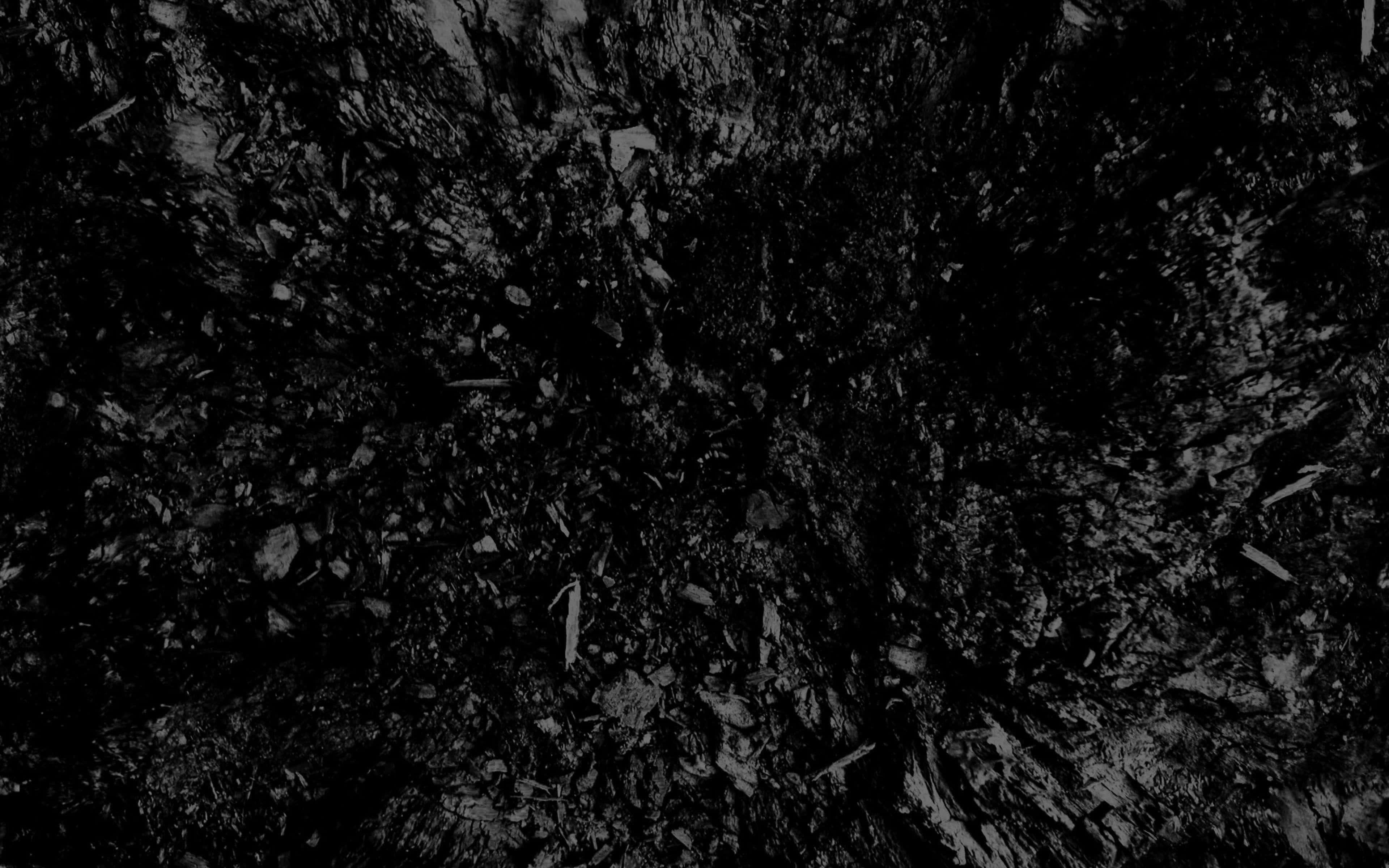 Charcoal 桌布 壁紙 — 黑色表面上散落著深色木炭碎片的特寫，帶有微妙的灰色亮點。