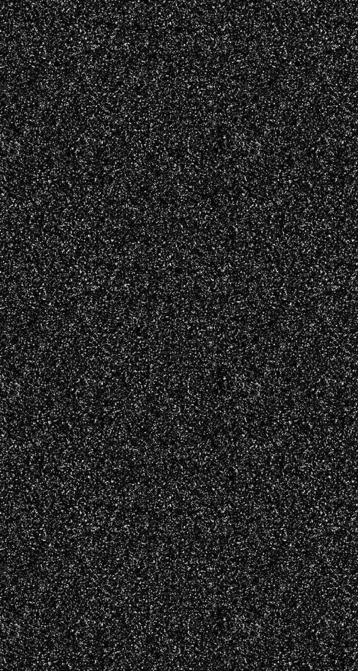 Black Glitter 桌布 壁紙 — 黑色表面的特寫，上面佈滿細小的白色亮粉顆粒，營造出有紋理的閃爍效果。